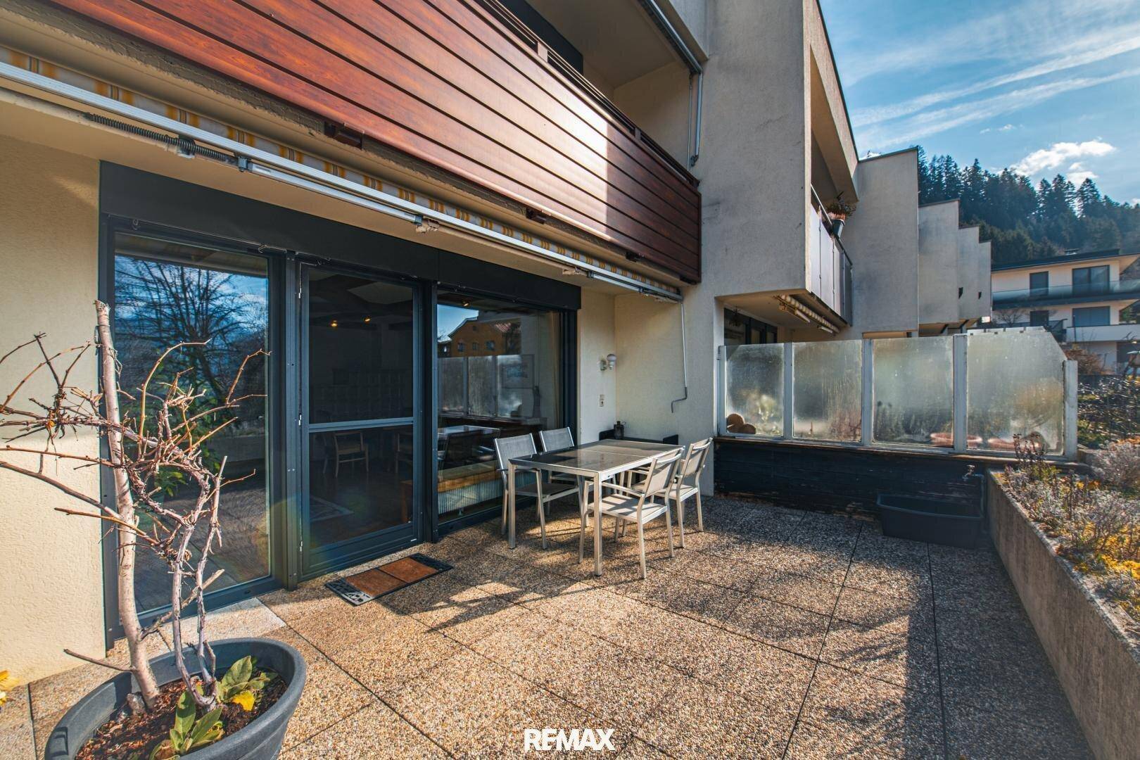 Sonniger Terrassenbereich mit Sitzgelegenheiten und Blick auf die umliegende Landschaft.