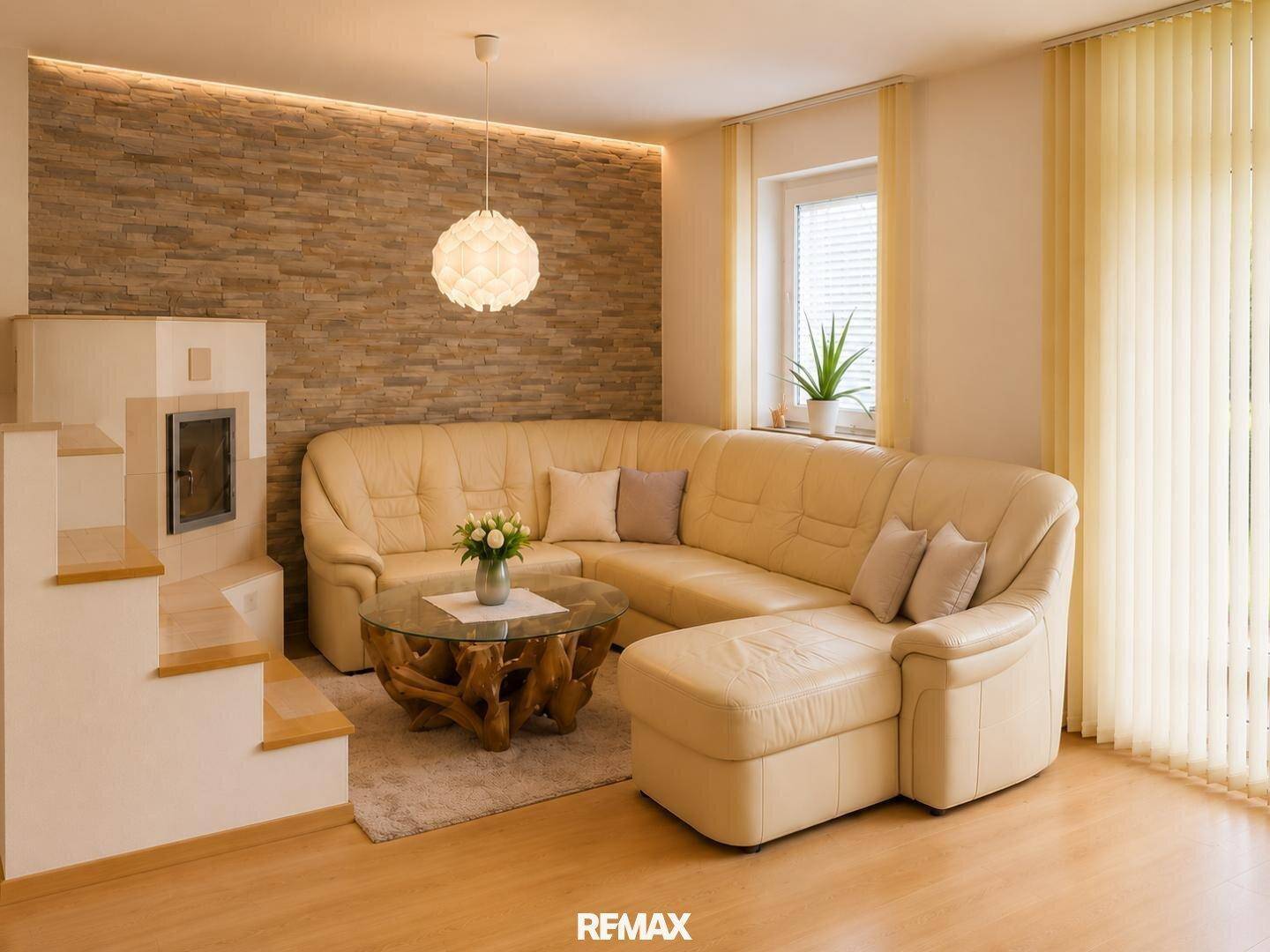 Helles Wohnzimmer mit beigem Ecksofa, Kamin und Steinwandakzent.
