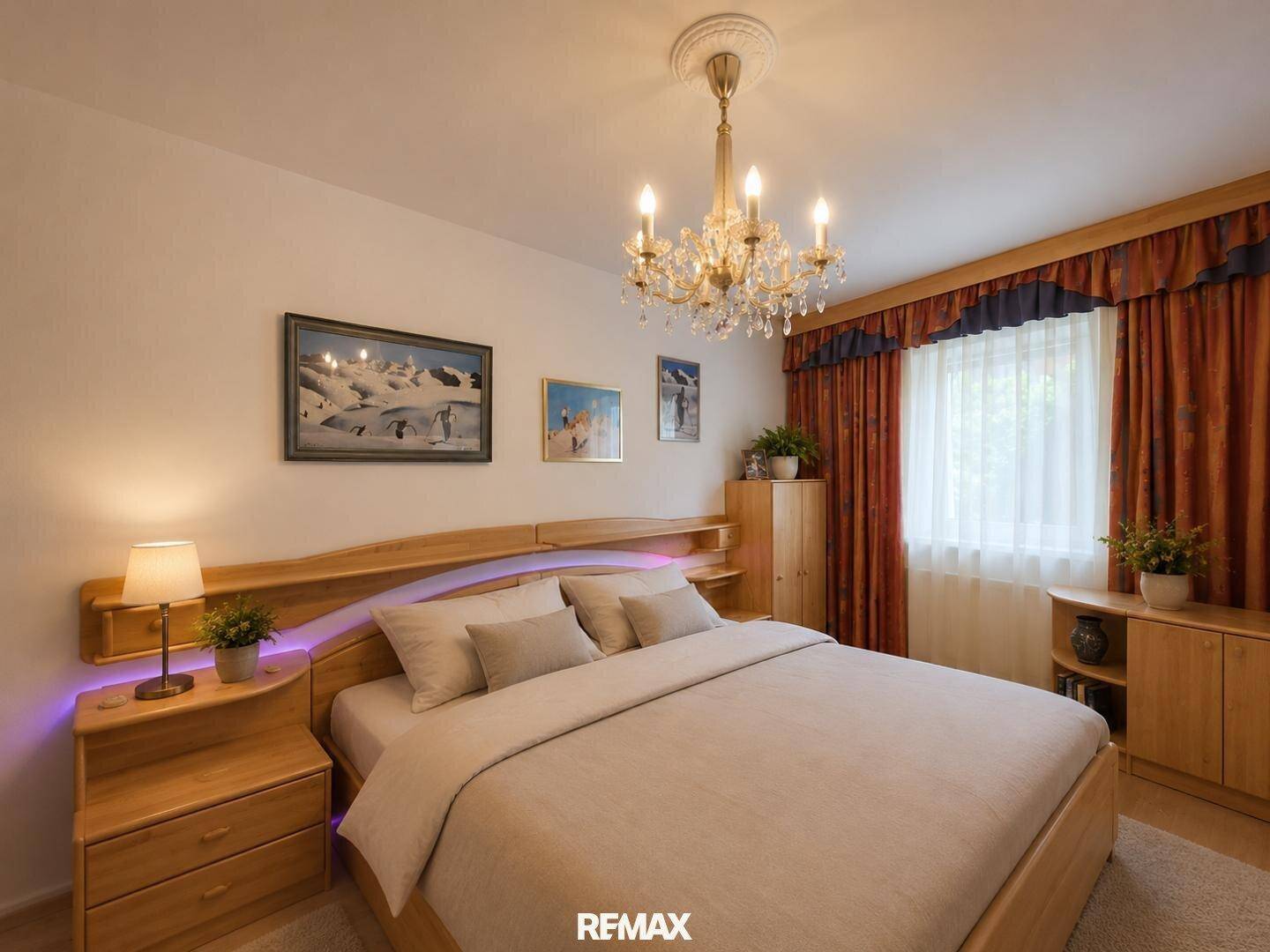 Helles Schlafzimmer mit Holzbett, Nachttischen und dekorativem Kronleuchter.