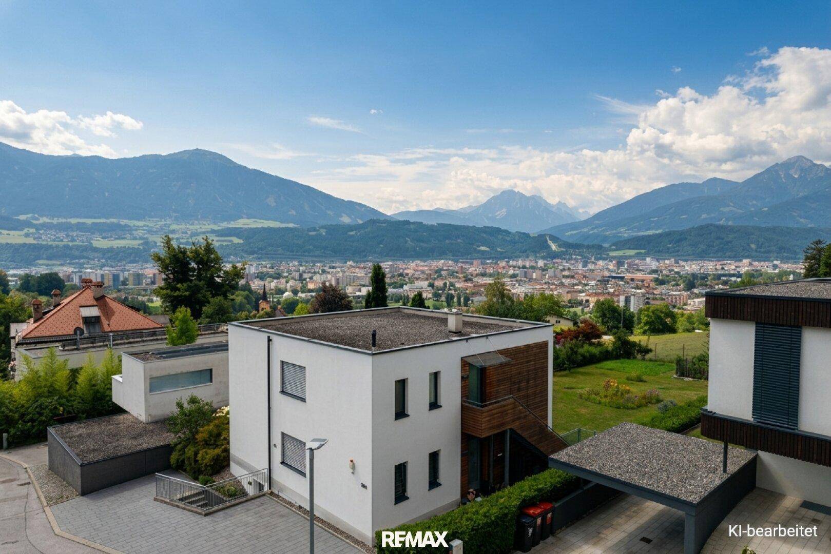 Modernes Wohnhaus mit Flachdach und Carport, gelegen mit weitem Blick über die Stadt und Berge.