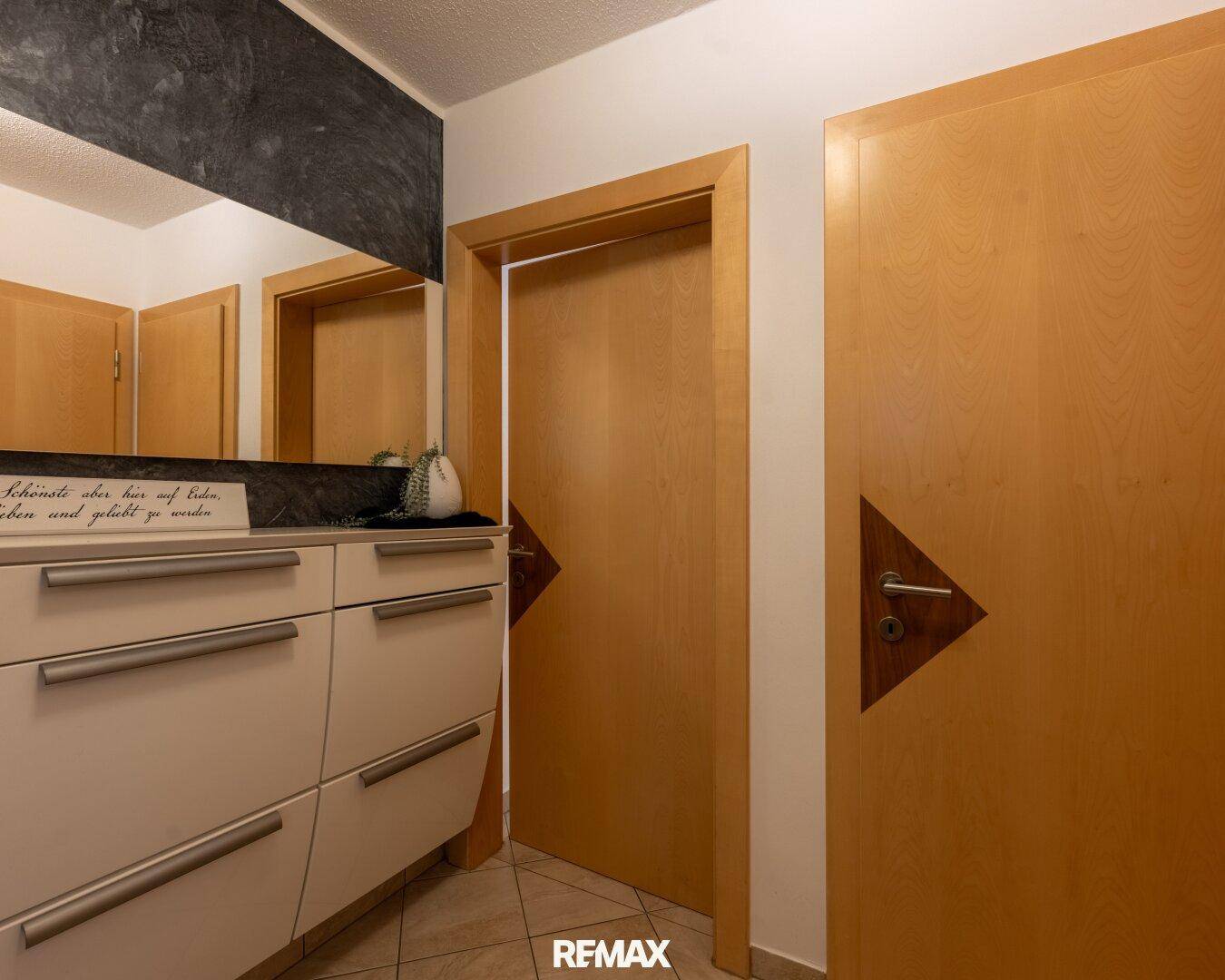 Heller Flur mit Einbauschrank und Holztüren, der zu weiteren Räumen führt.