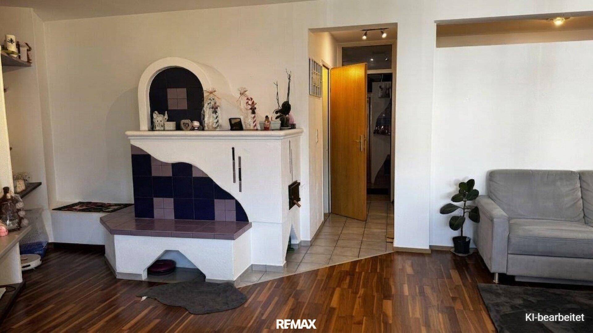 Gemütliches Wohnzimmer mit traditionellem Kachelofen und Holzboden.