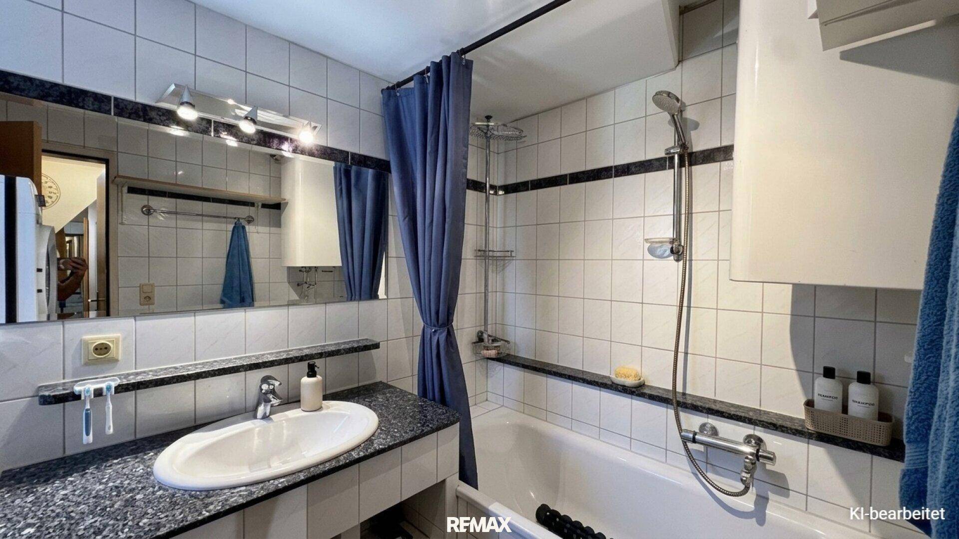 Badezimmer mit Badewanne, Duschvorhang, Einzelwaschbecken und weißen Fliesen.
