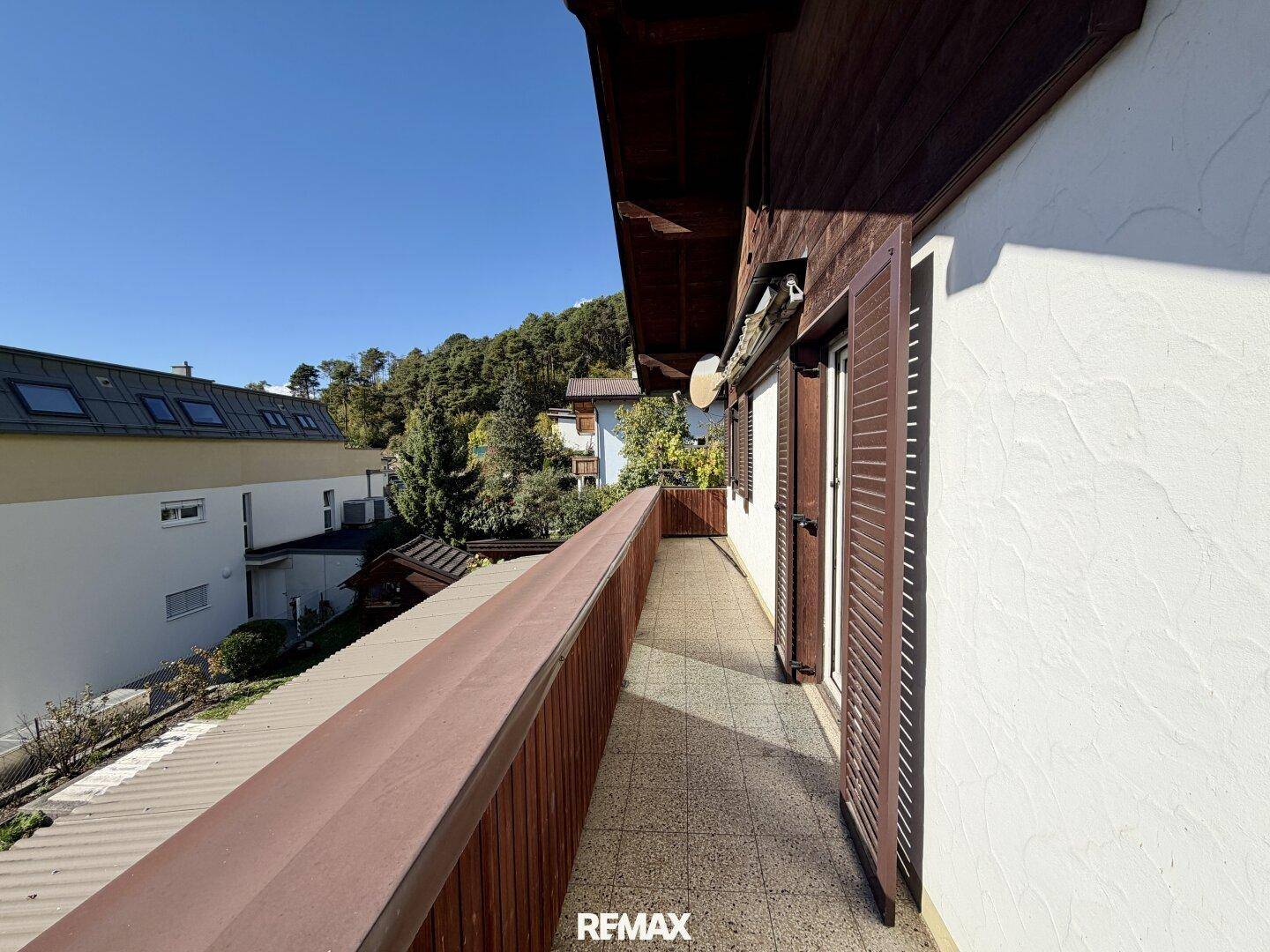 Langer, schmaler Balkon mit Fliesenboden und Blick auf die umliegende Bebauung.