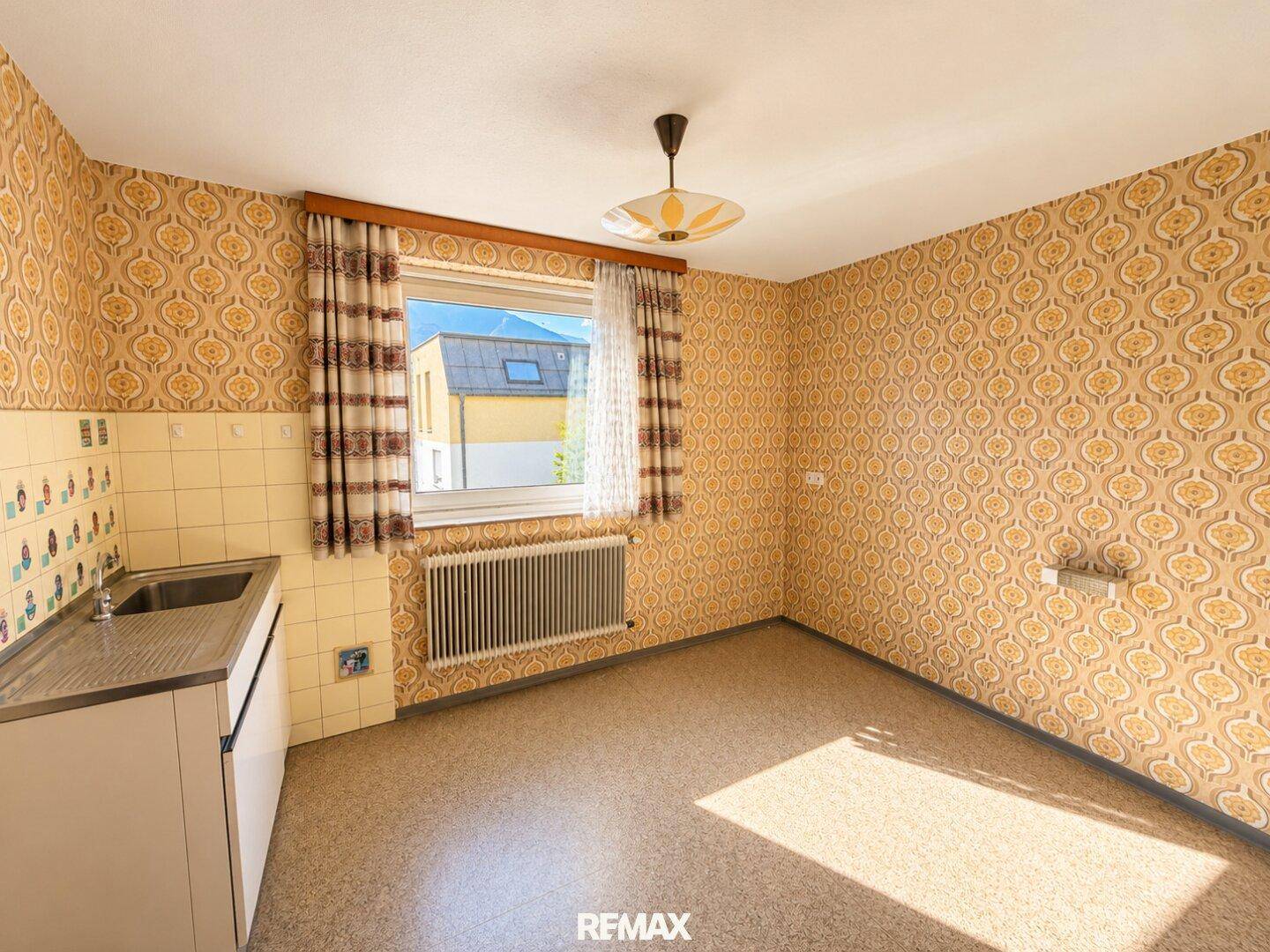 Kleine Küche oder Hauswirtschaftsraum mit Retro-Tapete, Spüle und Fenster.