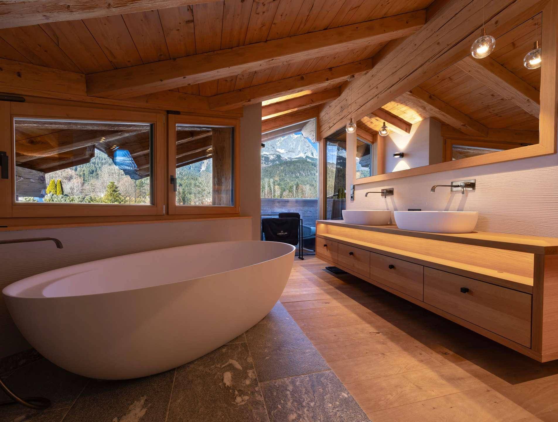 Modernes Badezimmer mit freistehender Badewanne, Doppelwaschbecken und Holzbalkendecke.