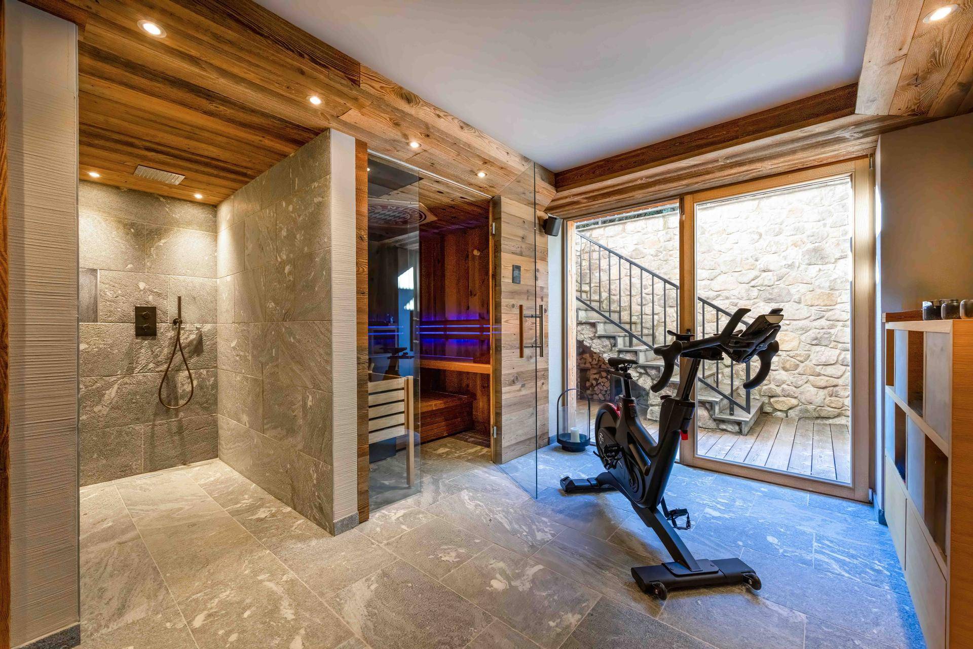 Wellnessbereich mit Sauna, Dusche und Fitnessgerät, ideal für Entspannung und Sport.