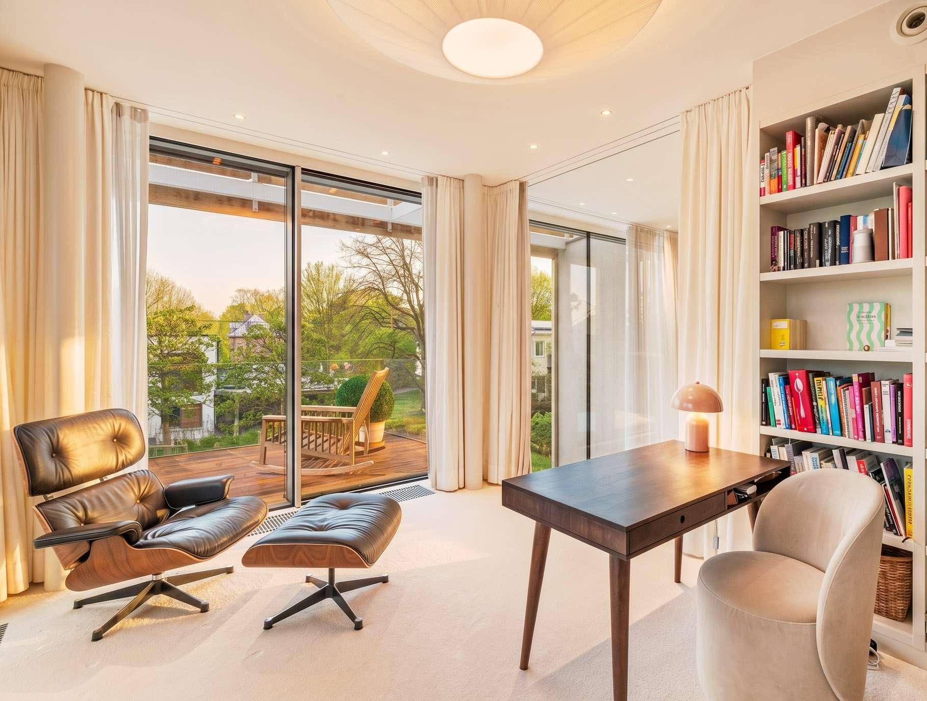 Ruhiges Arbeitszimmer mit Bücherregal und direktem Zugang zu einer Holzterrasse im Grünen.