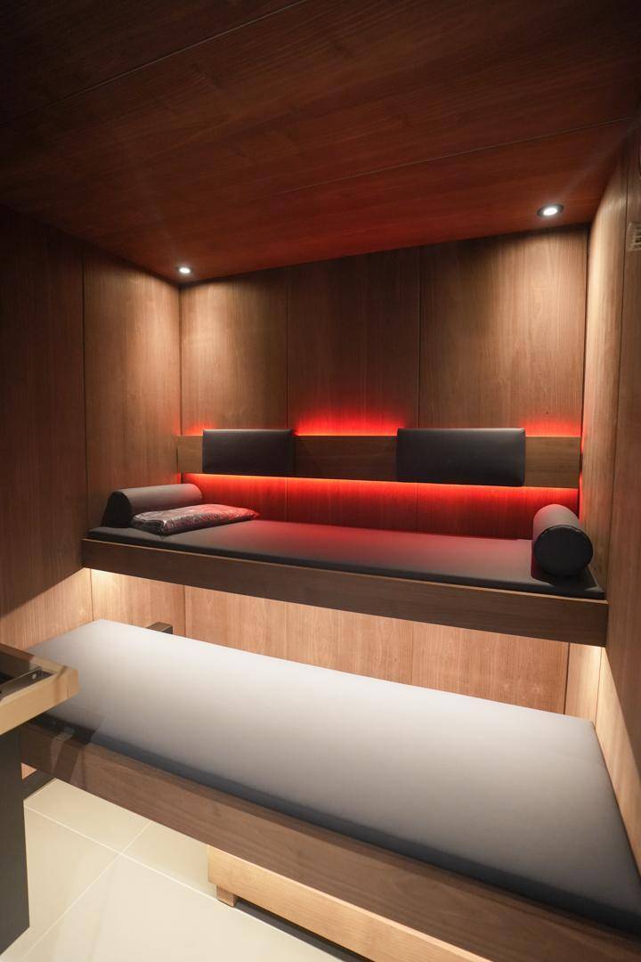 Entspannungsbereich mit Holzwänden und indirekter Beleuchtung für private Wellness-Momente.