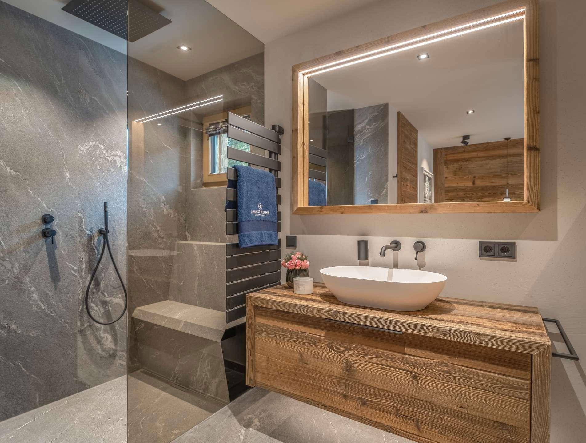 Modernes Badezimmer mit begehbarer Dusche, Holzwaschtisch, Einzelwaschbecken und beheiztem Handtuchhalter.