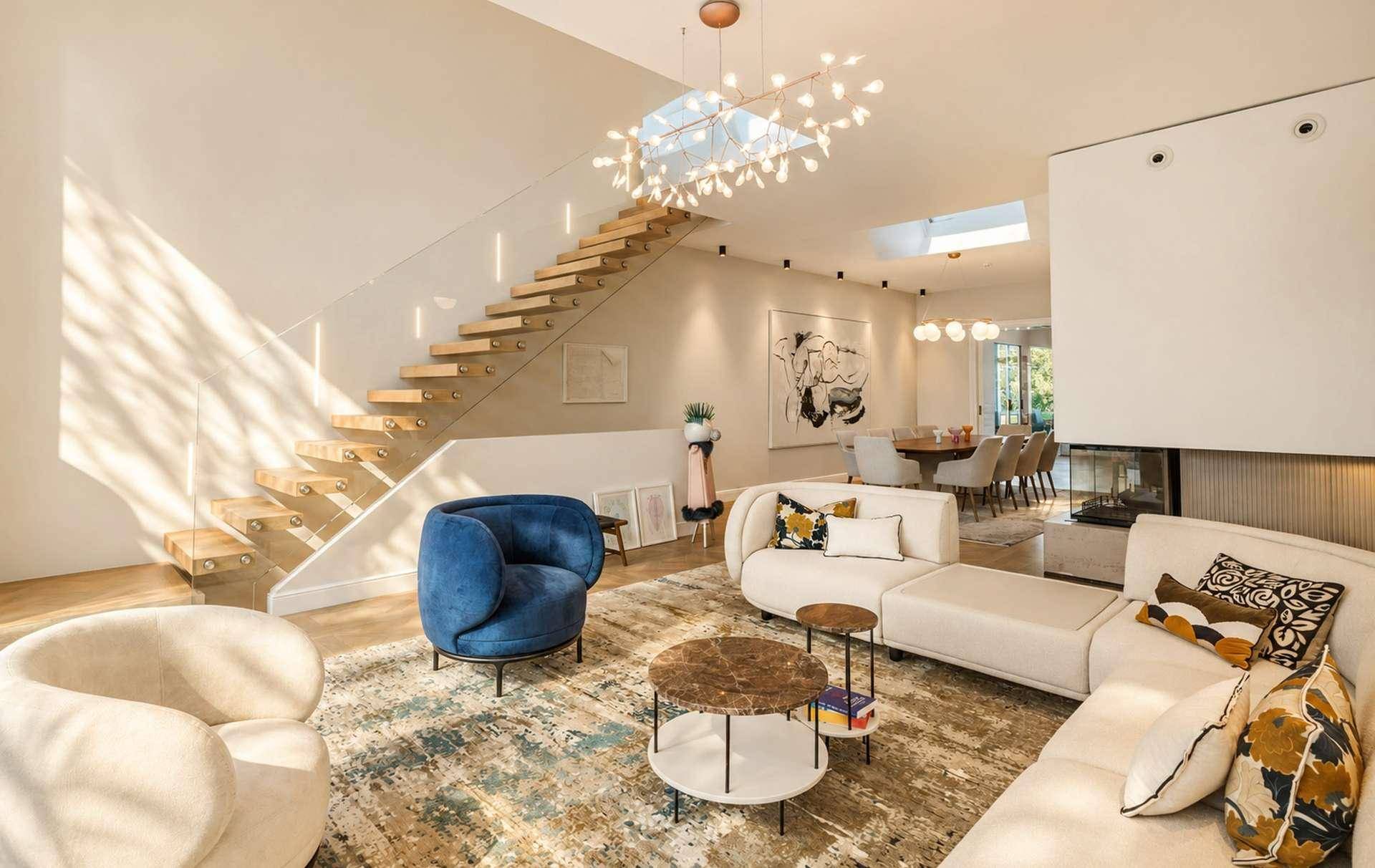 Heller Wohnbereich mit moderner Einrichtung, eleganter Treppe und Oberlicht für viel Tageslicht.