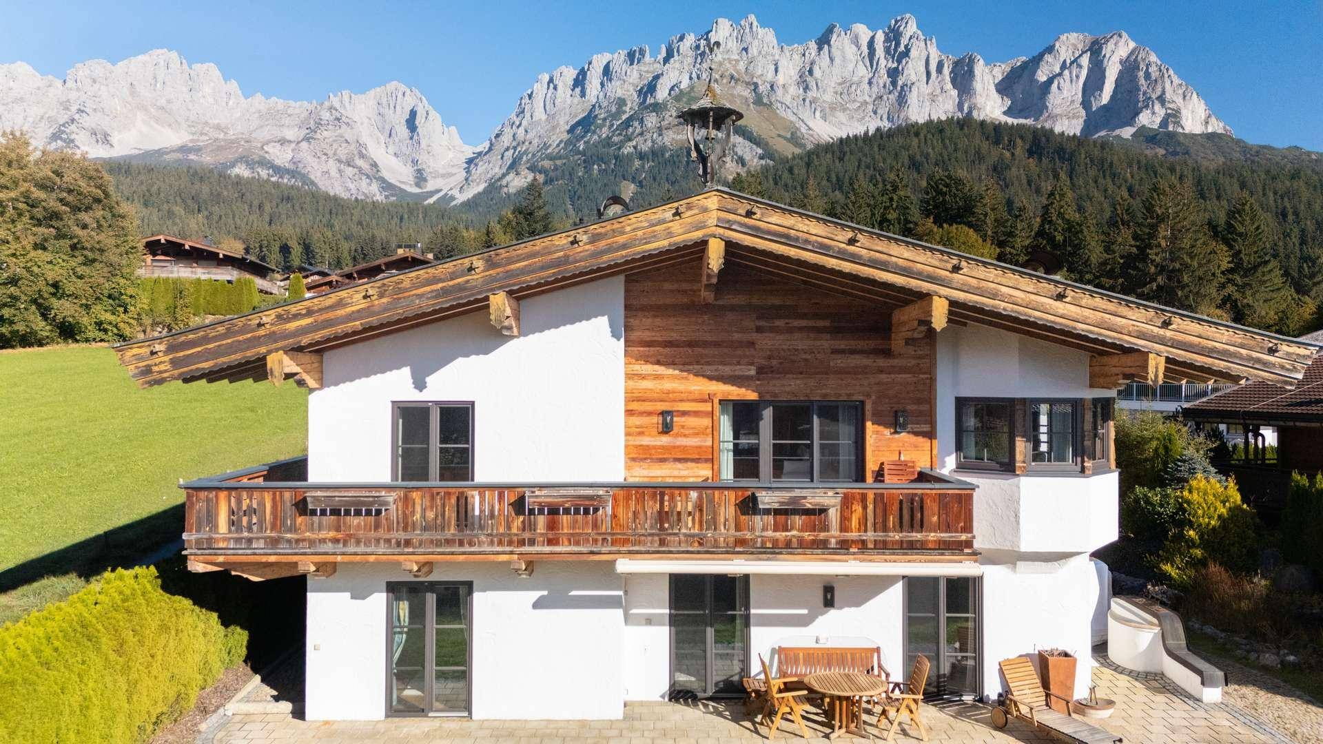 Traditionelles Alpenhaus mit Holzbalkonen und beeindruckendem Bergblick.