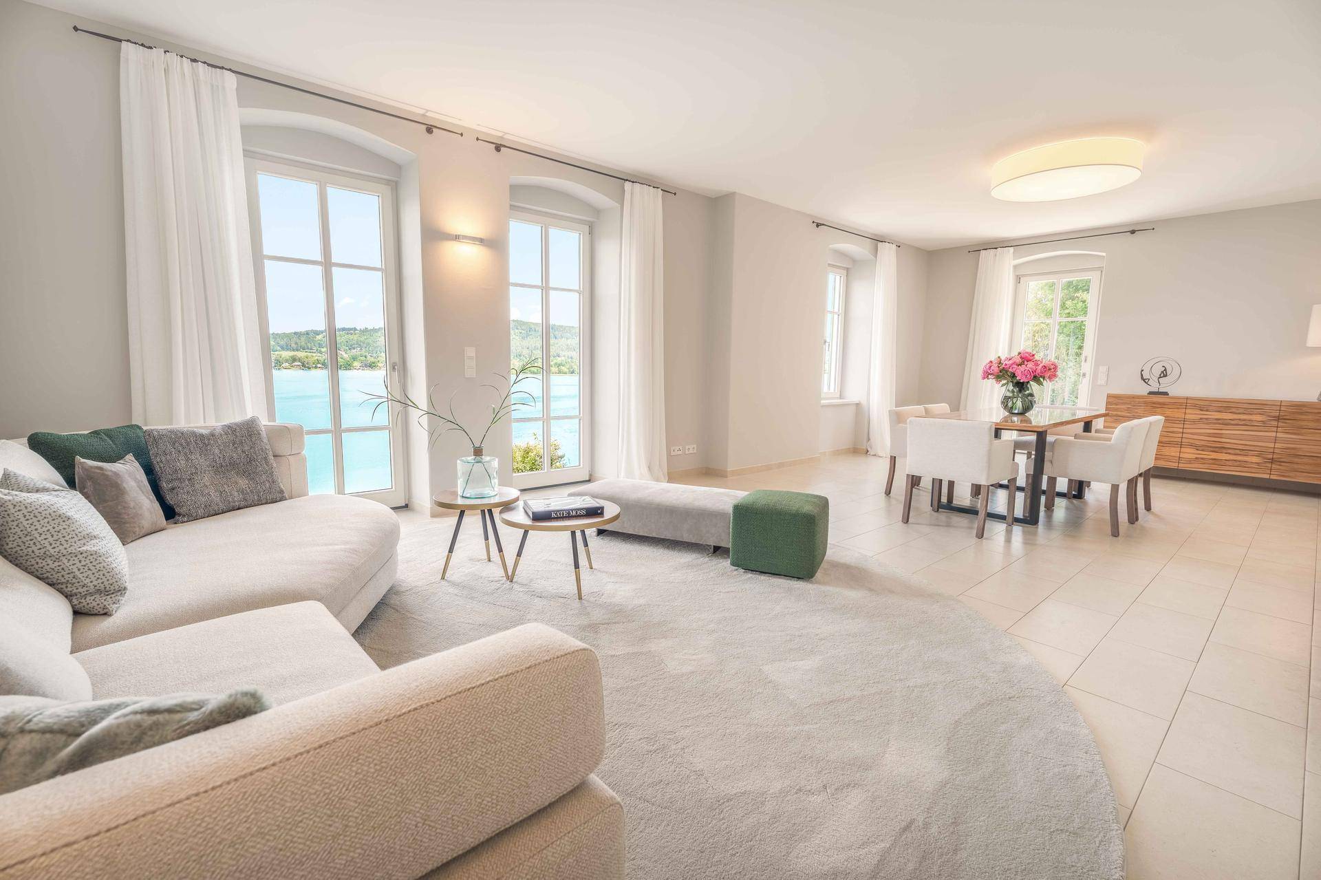 Lichtdurchfluteter Wohn- und Essbereich mit Seeblick, großen Fenstern und modernem Design.