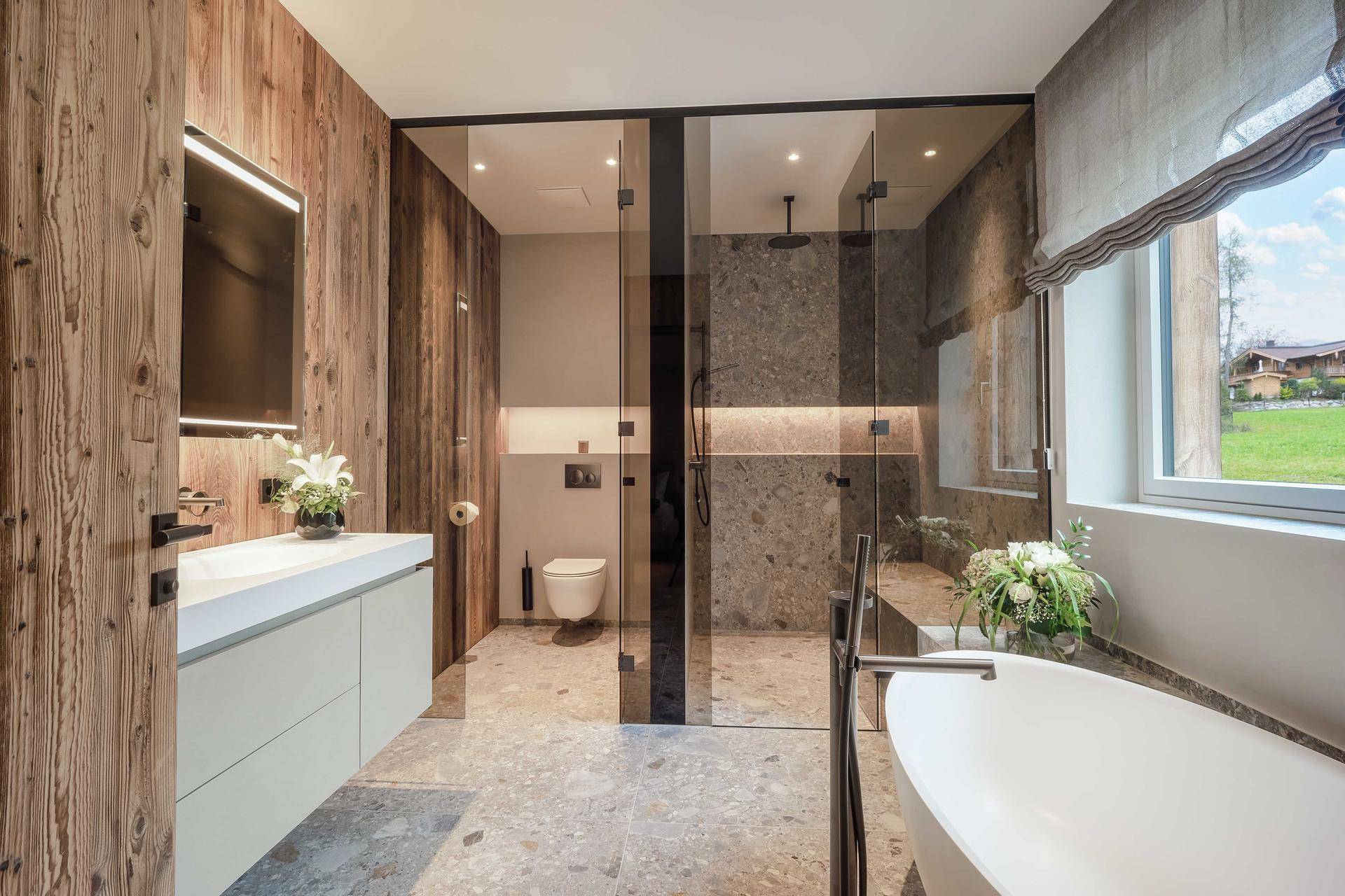 Luxuriöses Badezimmer mit freistehender Badewanne, begehbarer Dusche und Holzakzenten.
