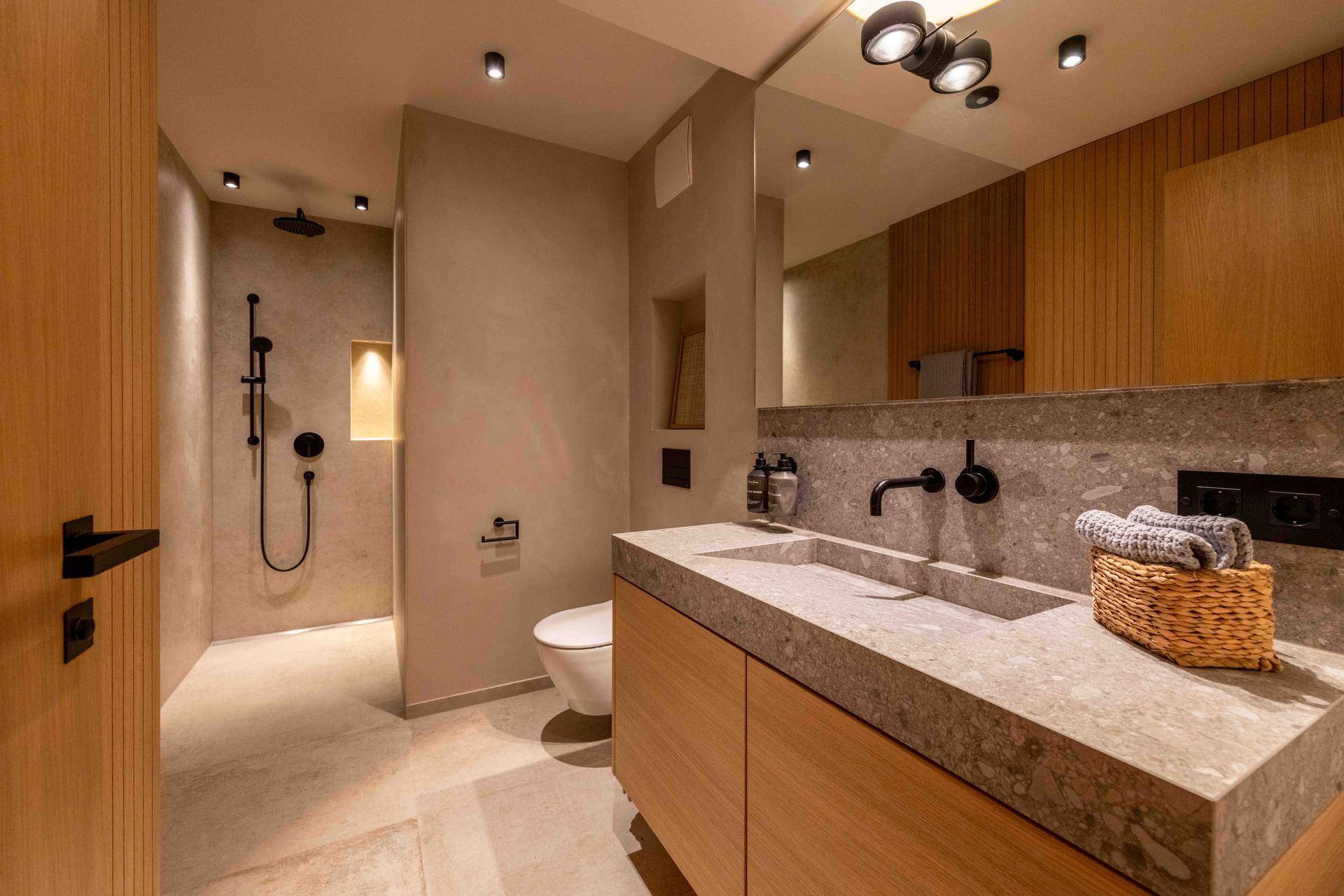 Elegantes Badezimmer mit begehbarer Dusche, Doppelwaschbecken und modernen Armaturen.