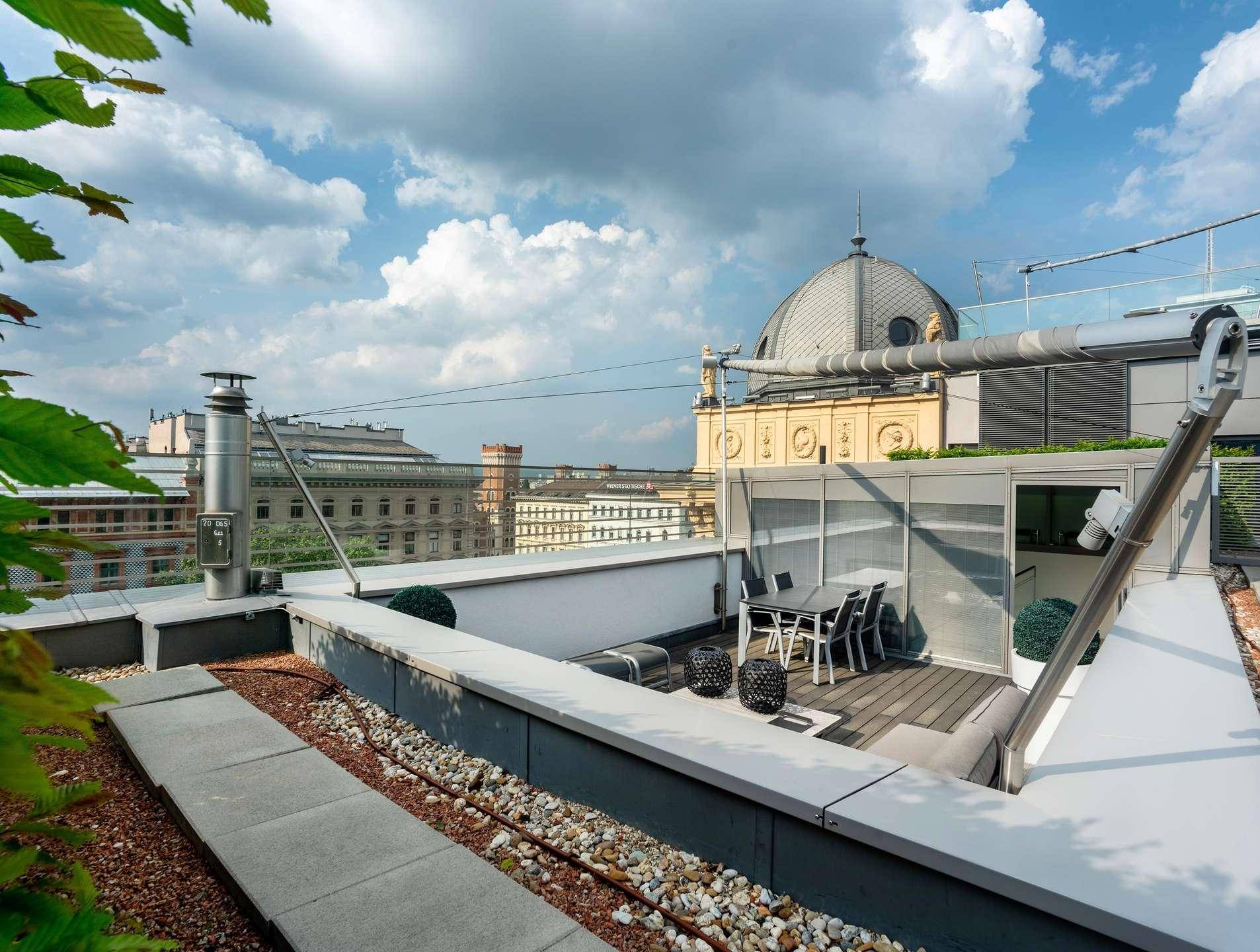 Exklusive Dachterrasse mit Essbereich und weitem Blick über die Dächer der Stadt.
