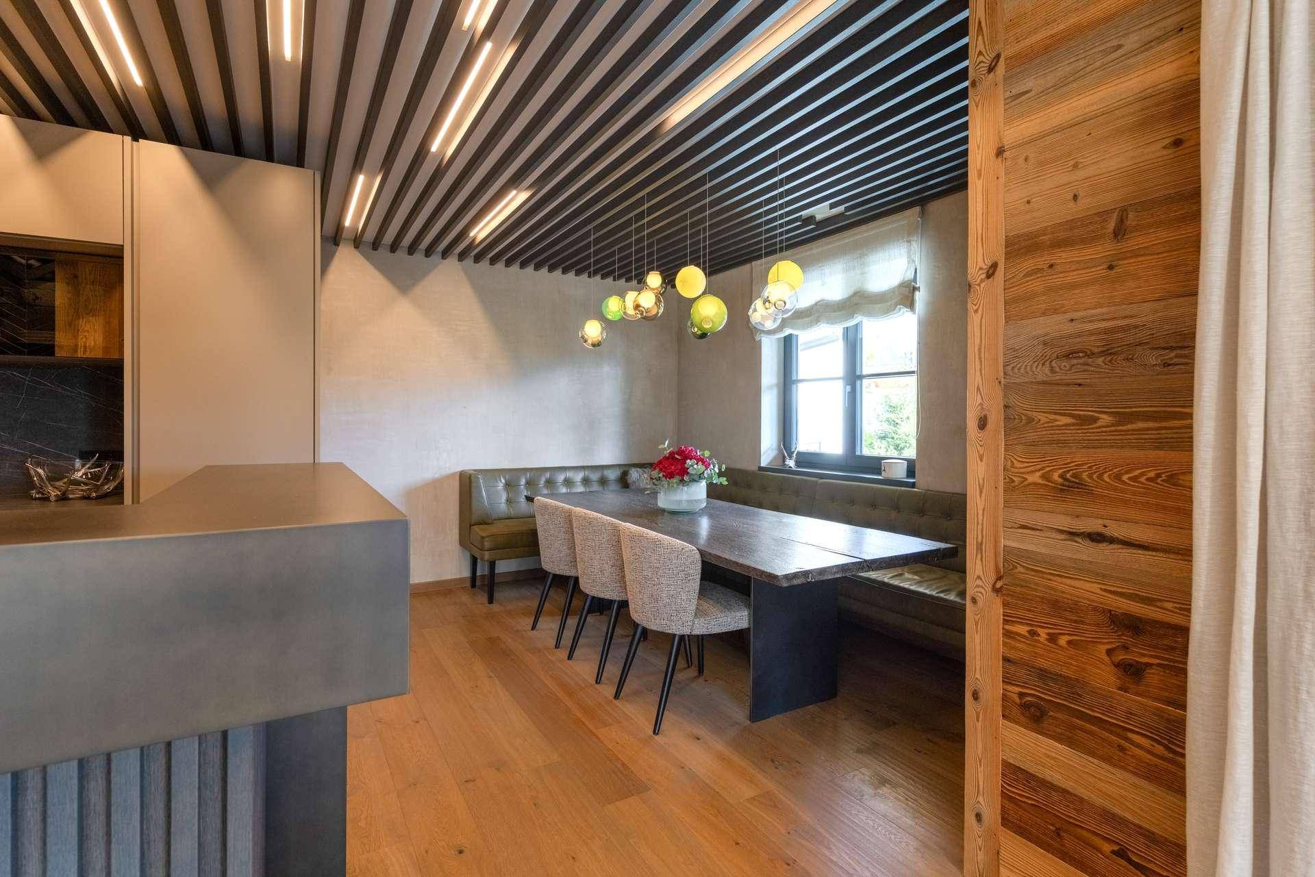 Gemütlicher Essbereich mit Eckbank, Holztisch und moderner Deckenbeleuchtung.