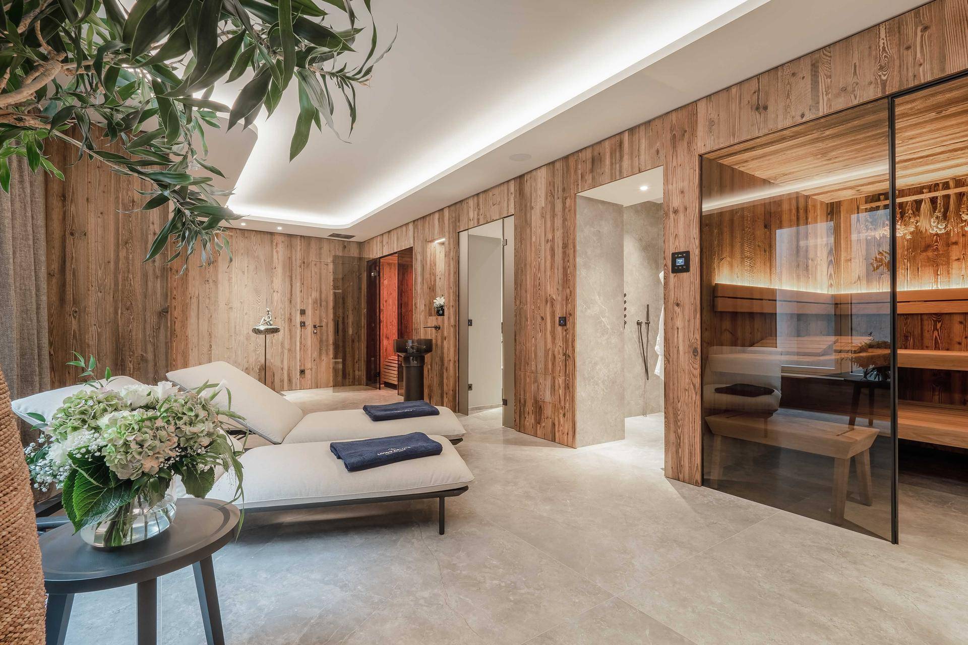 Exklusiver Wellnessbereich mit Sauna, Ruheliegen und Holzakzenten für Entspannung.