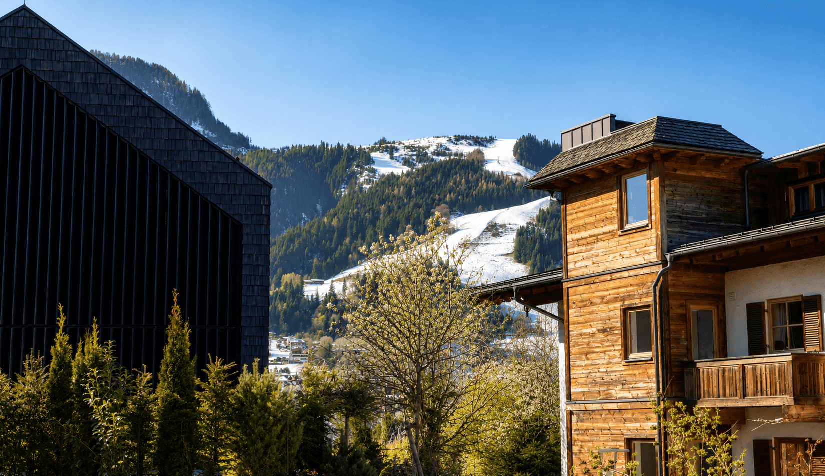 Blick auf schneebedeckte Berge, umrahmt von moderner und traditioneller Architektur.