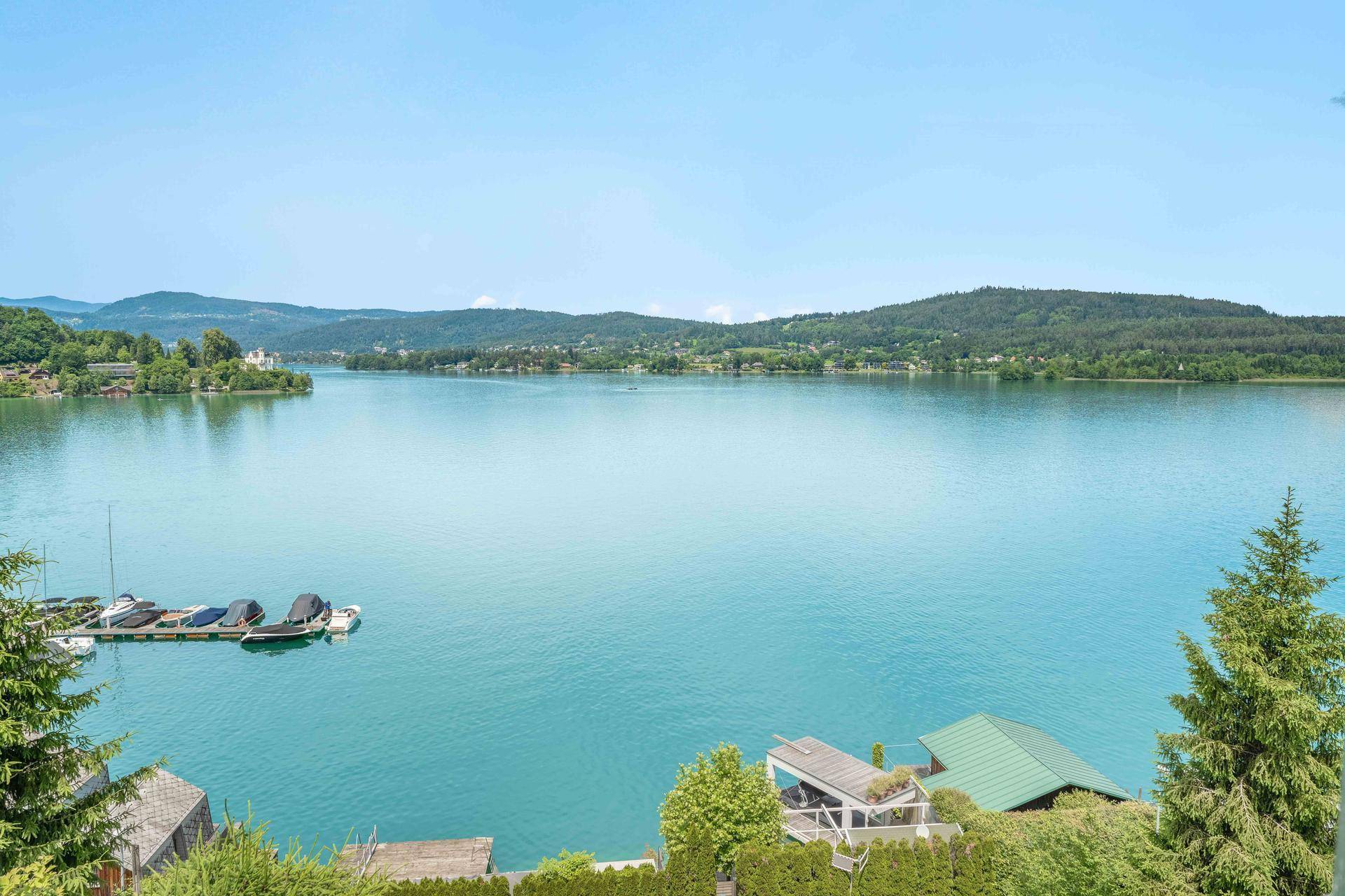 Weitläufiger Panoramablick auf den See und die umliegende grüne Landschaft.