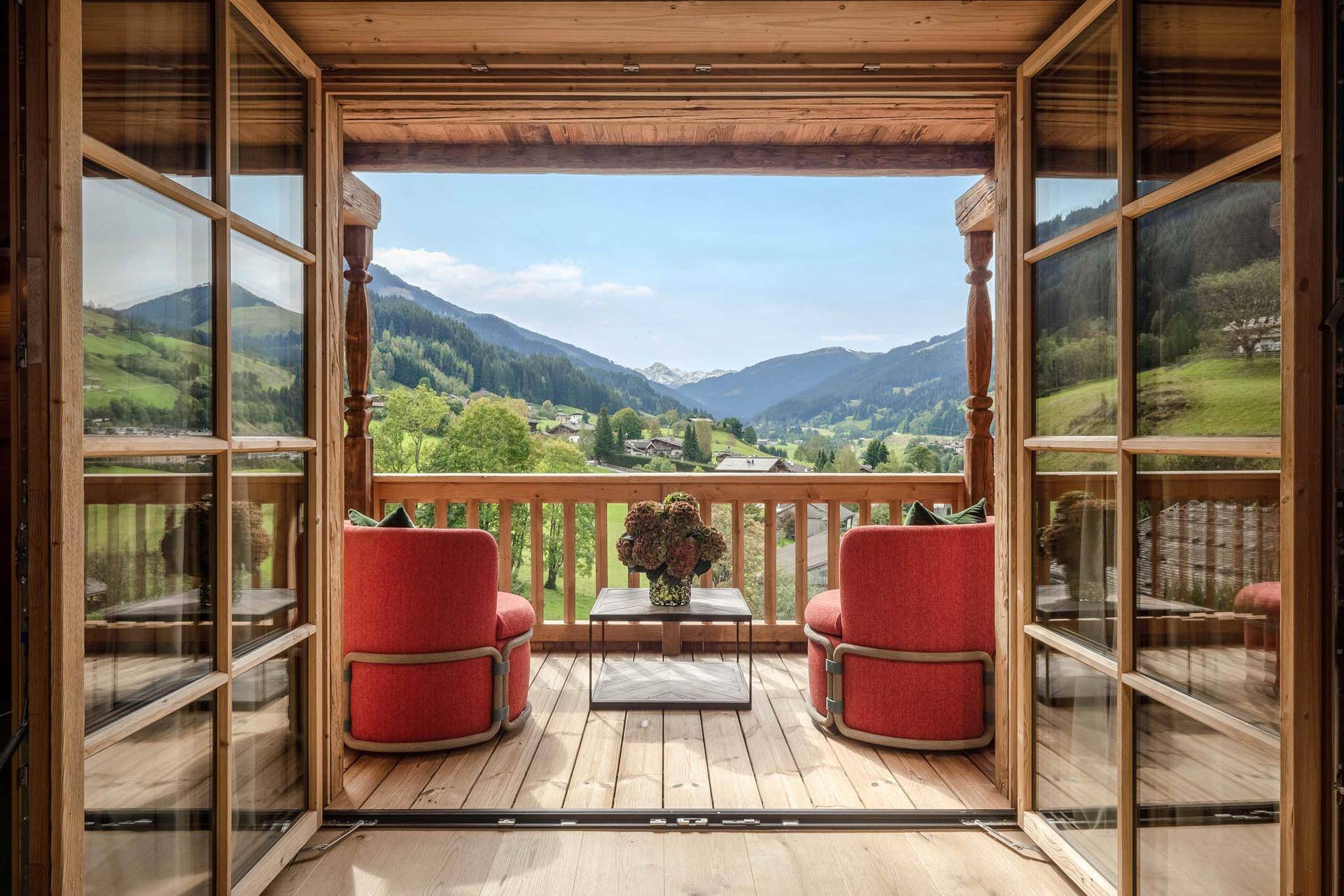 Gemütlicher Balkon mit bequemen Sesseln und atemberaubendem Blick auf die umliegende Berglandschaft.
