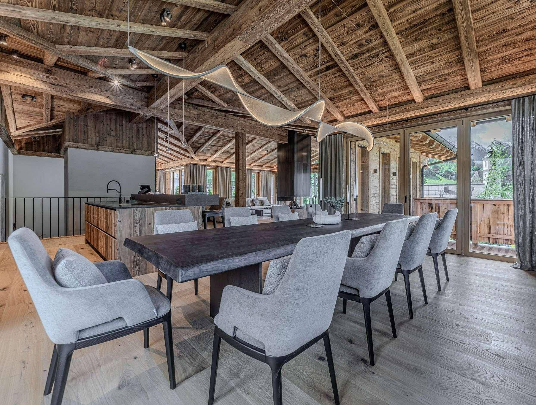 Eleganter Essbereich mit großem Holztisch, modernen Stühlen und Designerleuchten.
