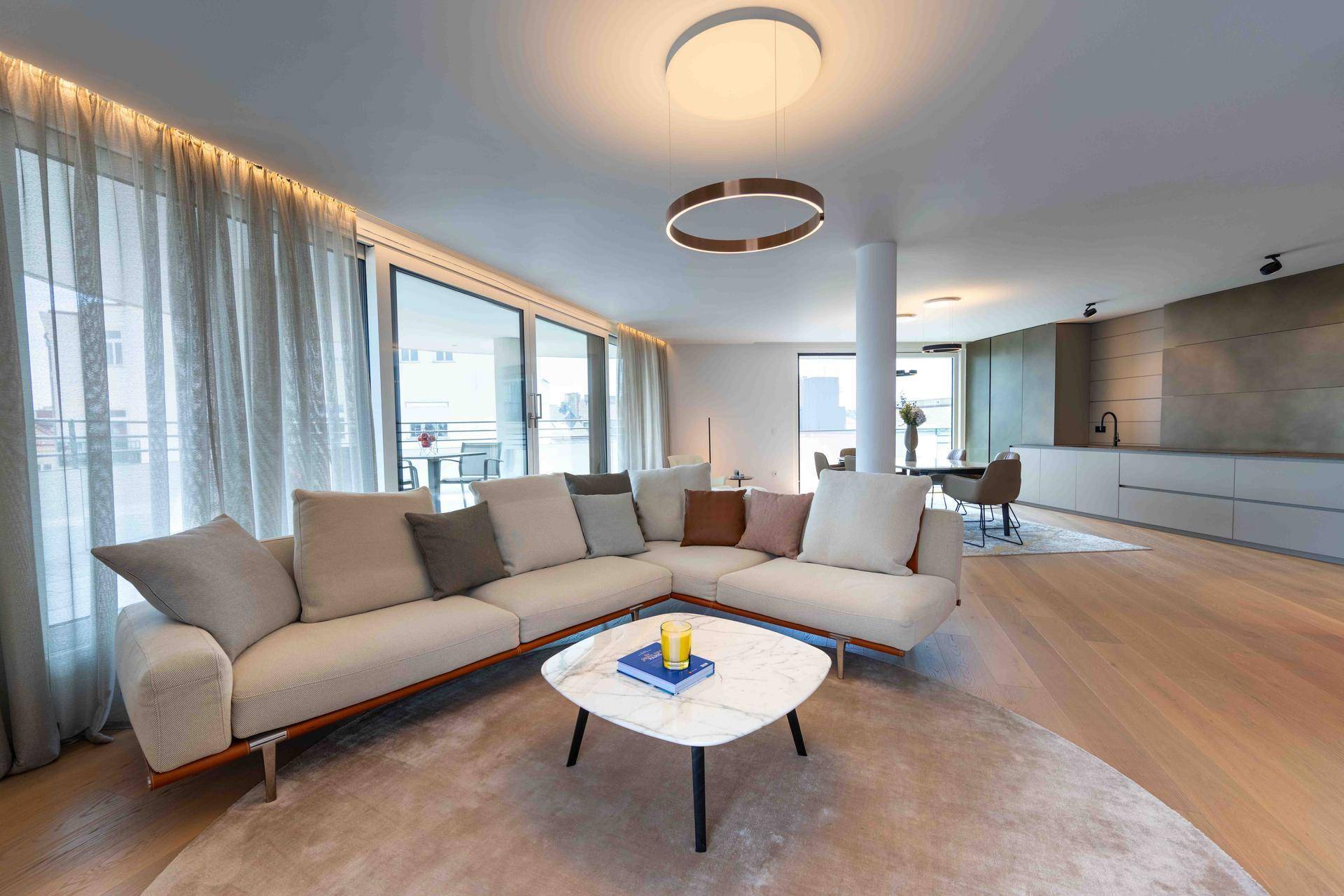 Geräumiger, offener Wohnbereich mit bequemer Couch, Holzboden und Zugang zur Terrasse.