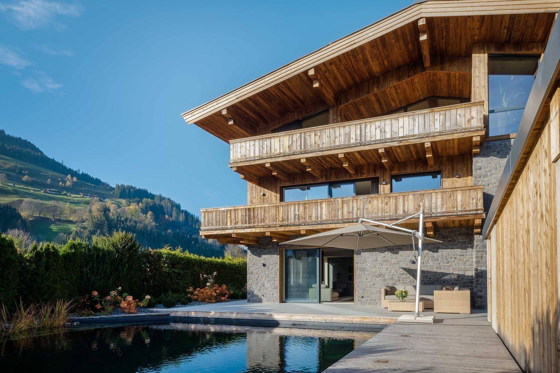 Exklusives Holzchalet mit Natursteinakzenten, großem Poolbereich und beeindruckendem Bergblick.
