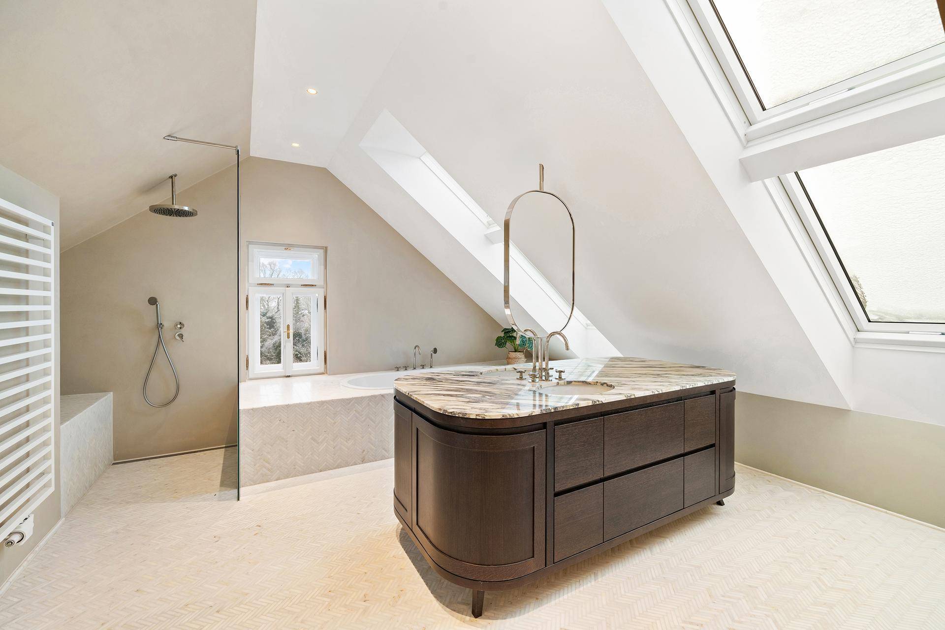 Modernes Dachgeschossbad mit Marmorwaschtisch, begehbarer Dusche und Dachfenstern.