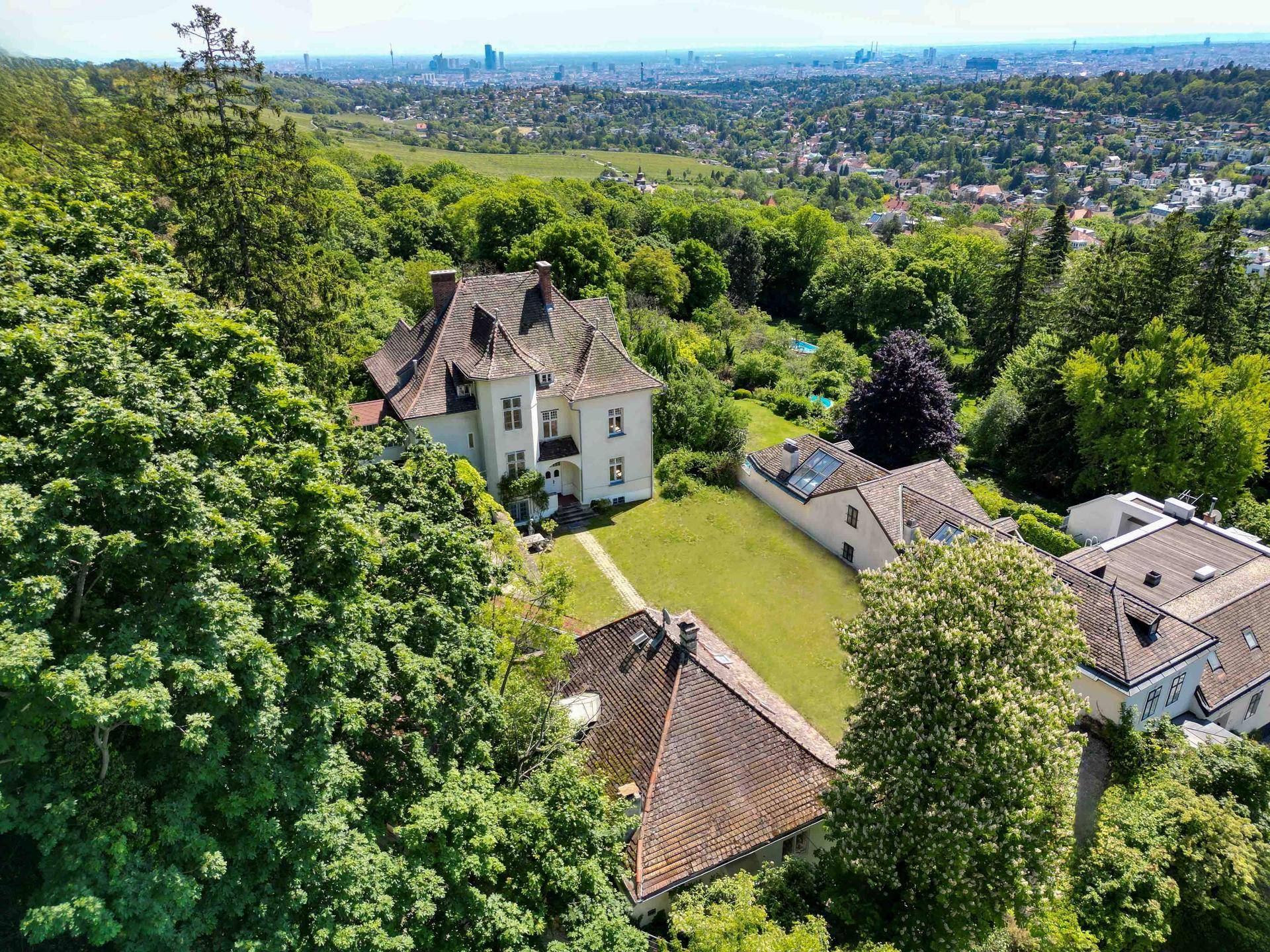 Weitläufiges Anwesen mit mehreren Gebäuden, großem Garten und beeindruckendem Stadtblick.