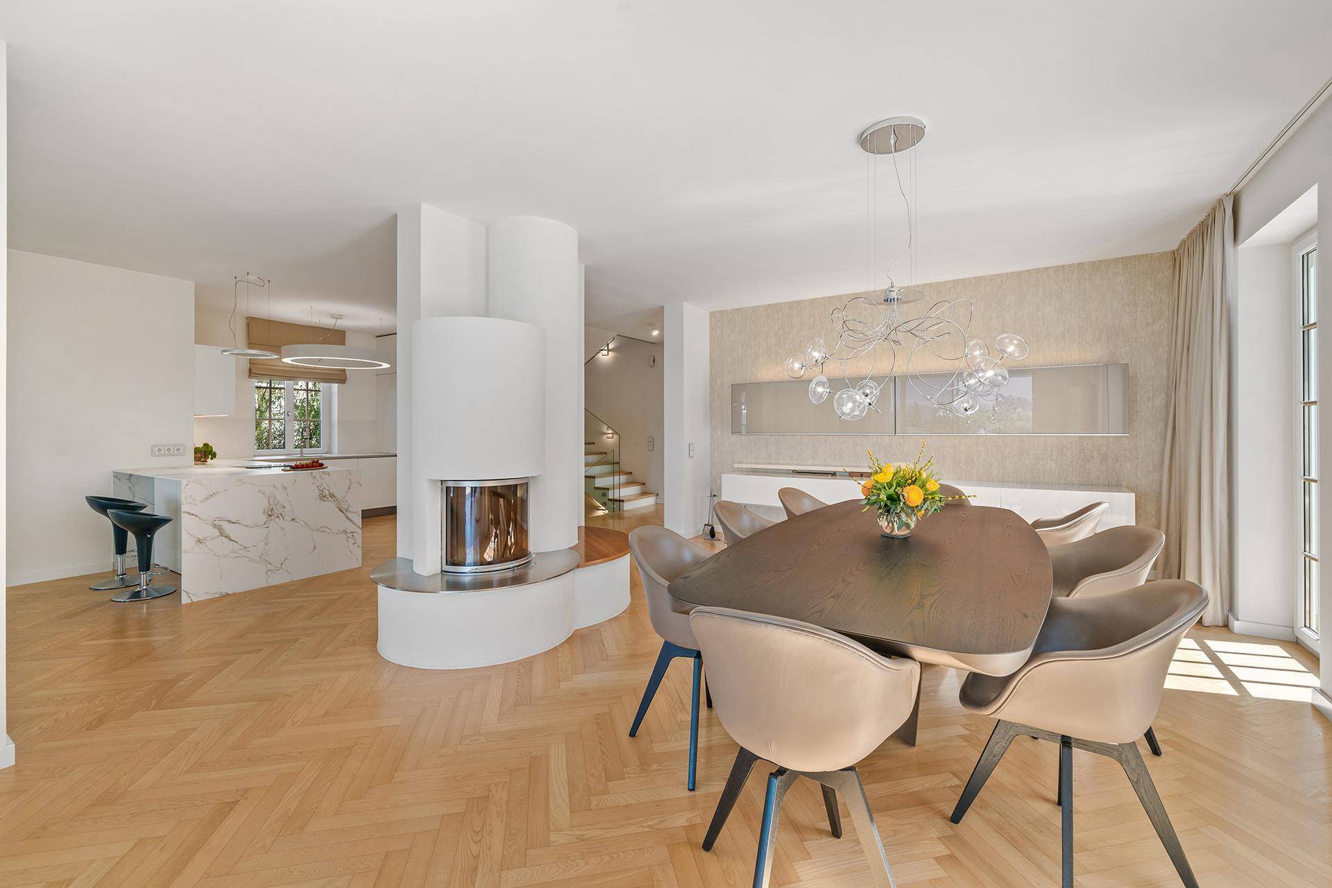 Eleganter Essbereich mit modernem Kamin, Parkettboden und offener Verbindung zur Küche.
