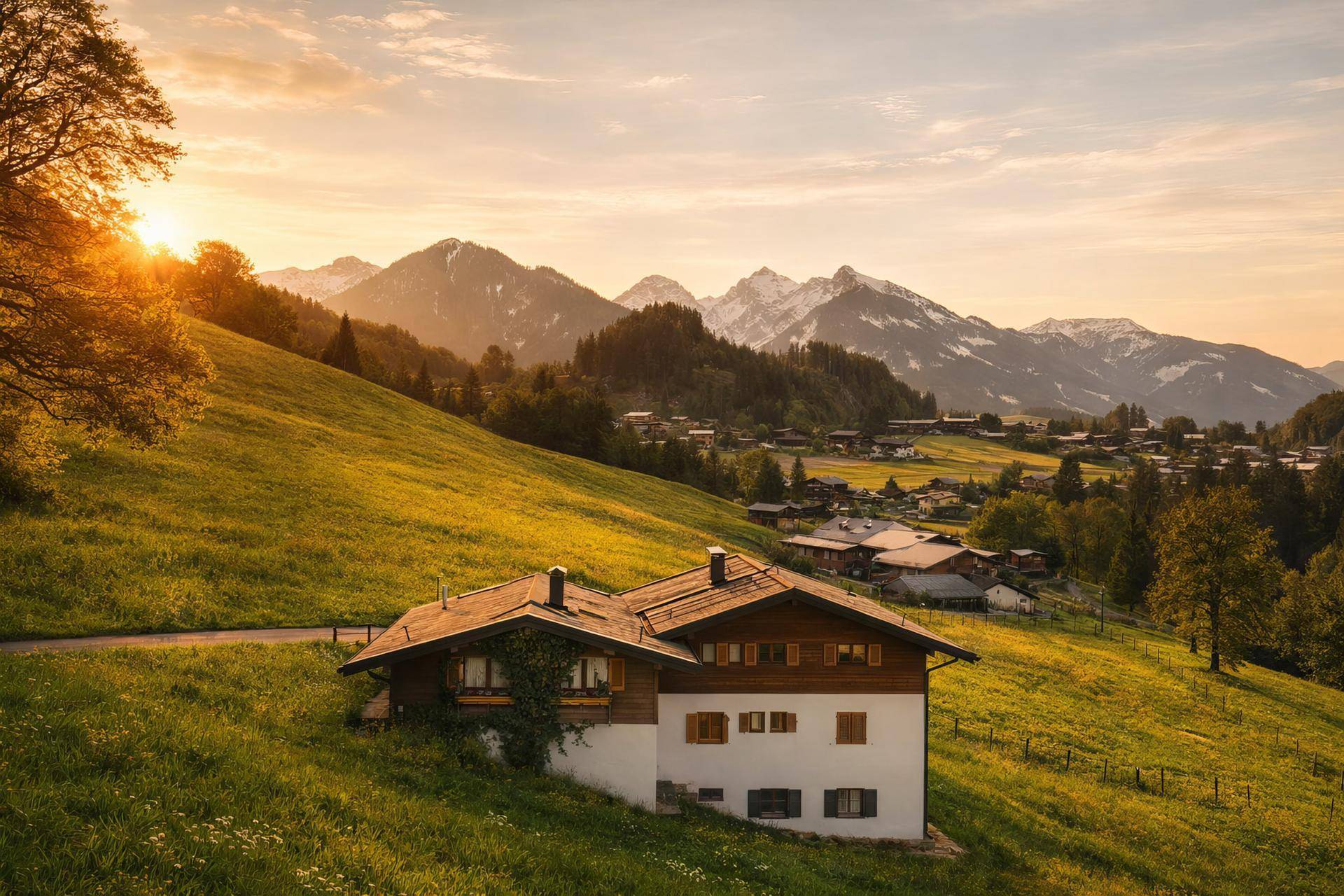 Haus auf einem sonnigen Hügel im warmen Licht des Sonnenuntergangs mit malerischem Bergblick.