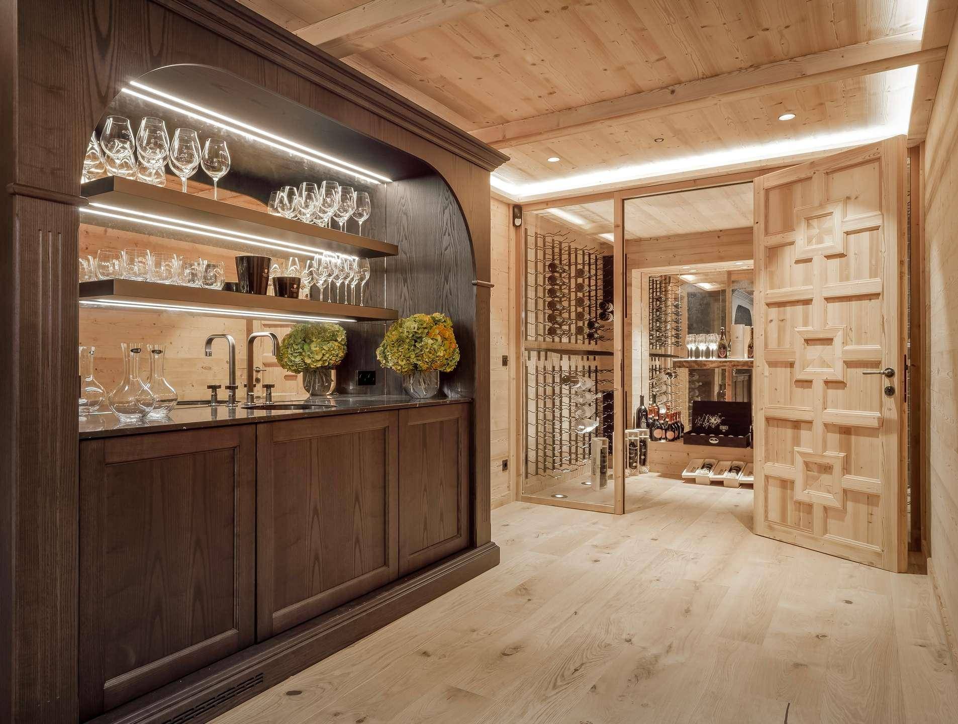 Stilvolle Hausbar mit integriertem Weinkeller, beleuchteten Regalen und hochwertigen Holzelementen.