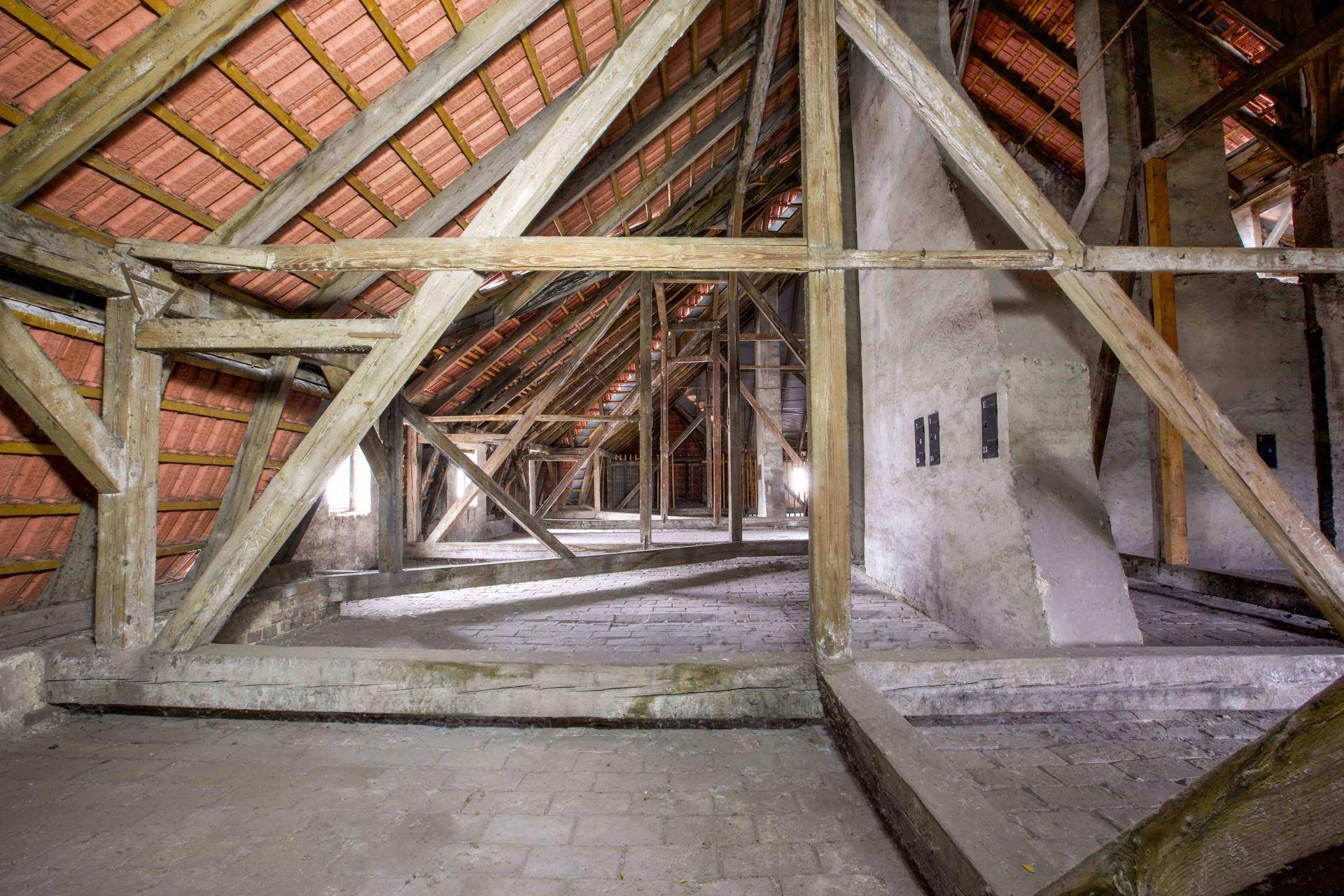 Weitläufiger Dachboden mit beeindruckender Holzkonstruktion, Ziegelboden und viel Potenzial für Ausbau.