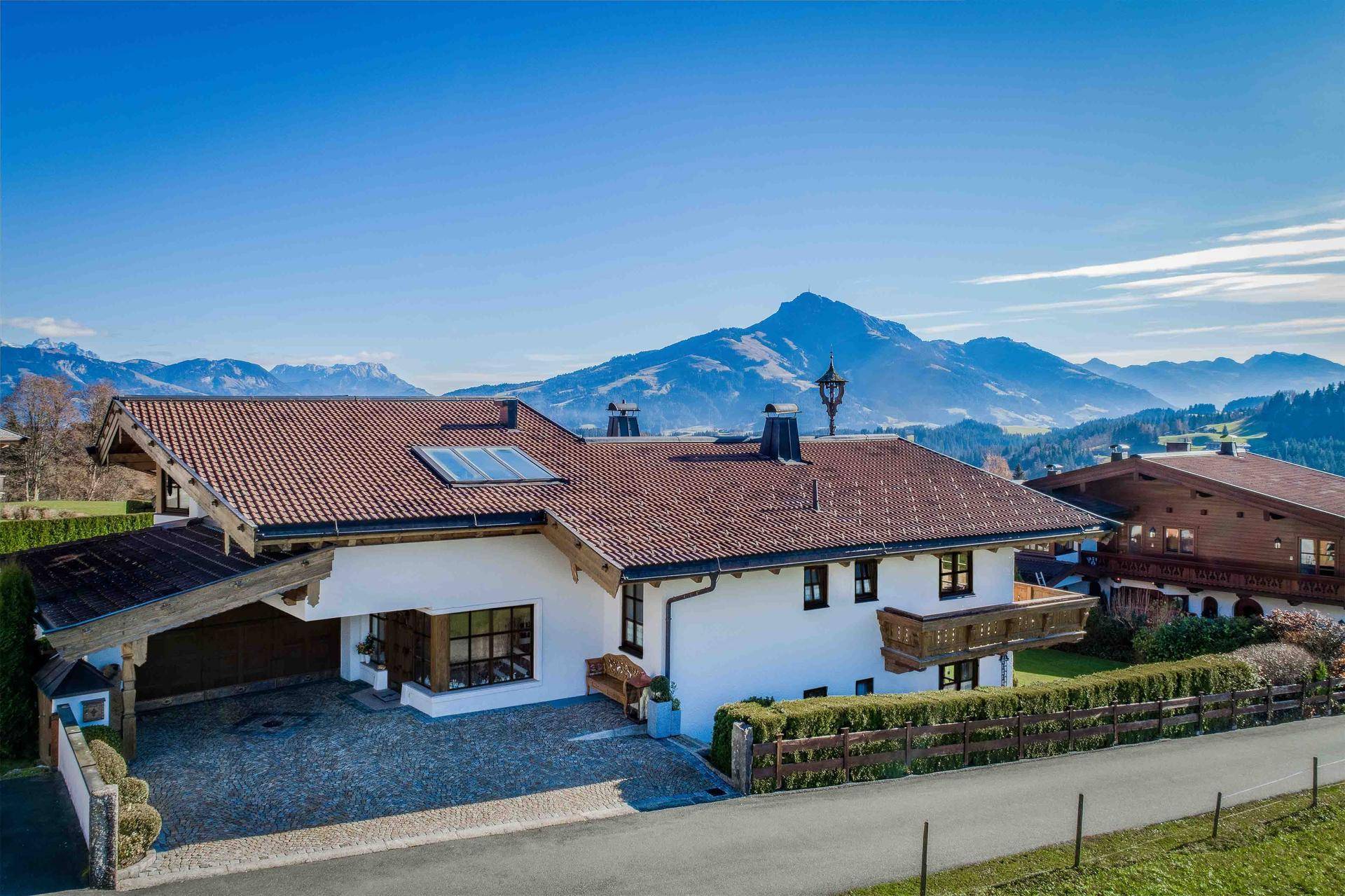 Großzügiges Alpenhaus mit Ziegeldach, Solaranlage und Panoramablick auf die Berge.