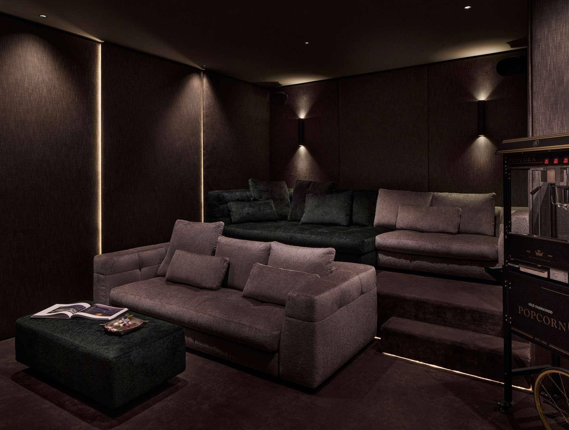Privater Kinoraum mit gestuften Sitzgelegenheiten und gemütlichen Sofas für Filmerlebnisse.