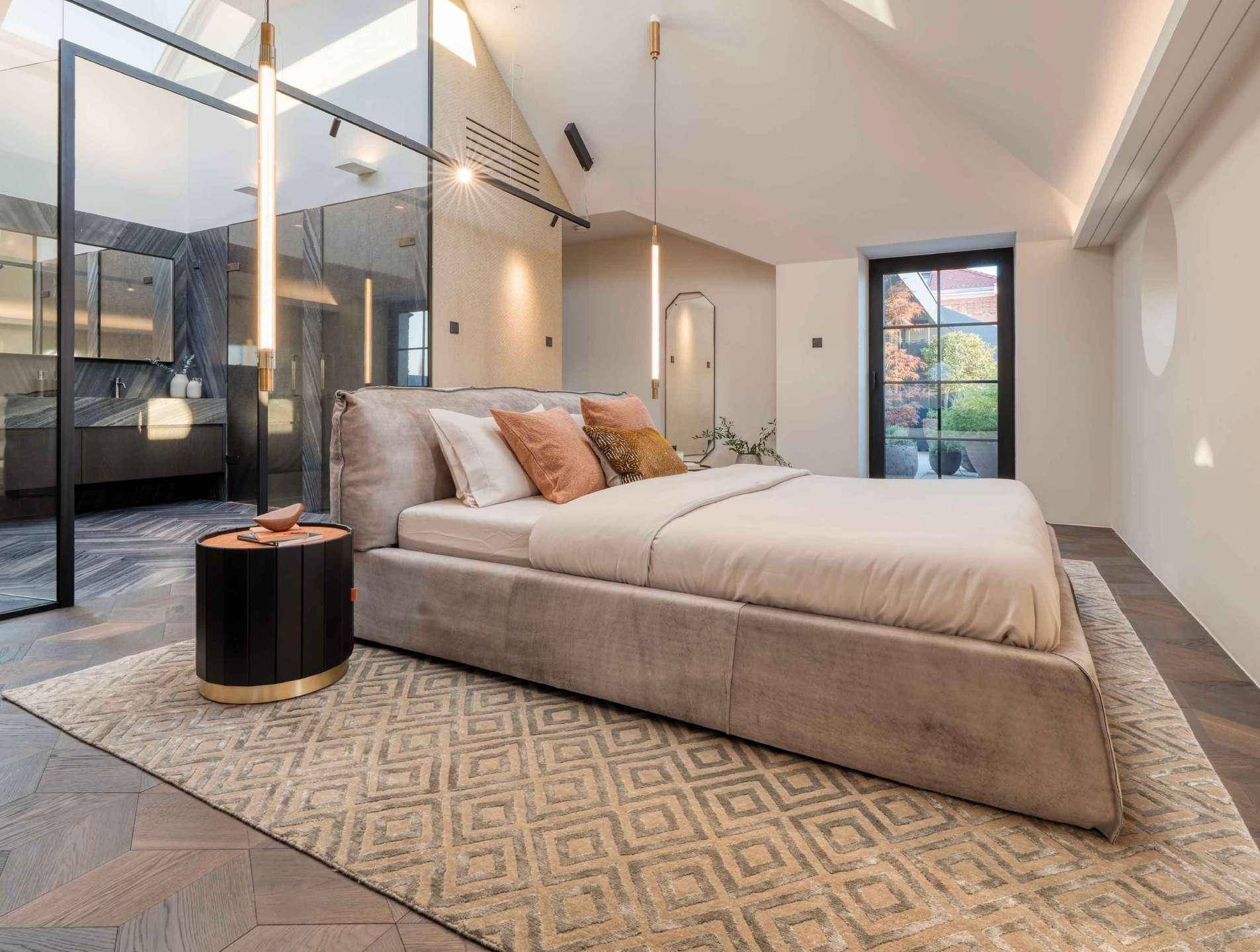Elegantes Schlafzimmer mit Dachschräge, modernem Design und offenem Badbereich.