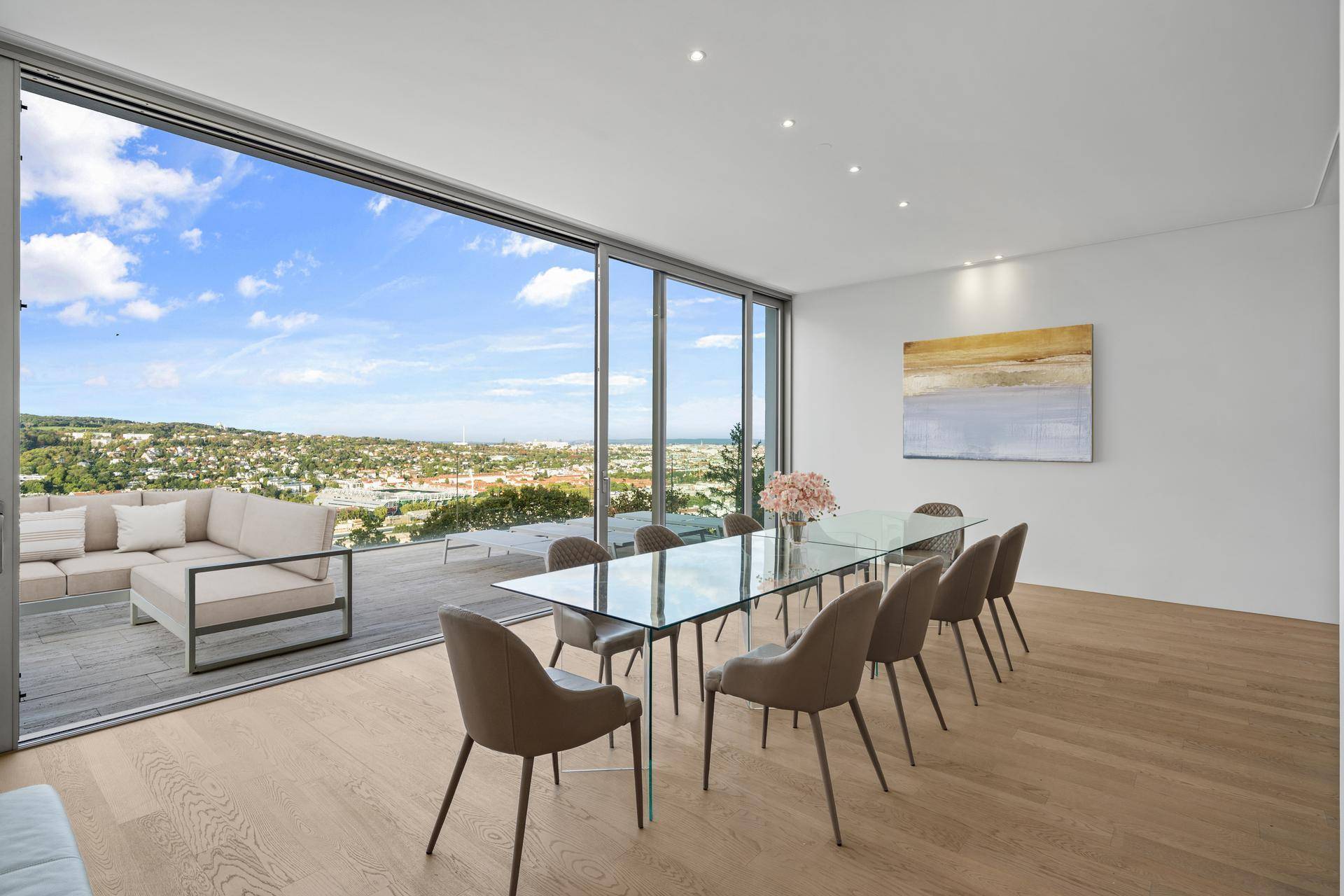 Eleganter Essbereich mit Glastisch, modernen Stühlen und direktem Zugang zur Terrasse mit malerischer Aussicht.