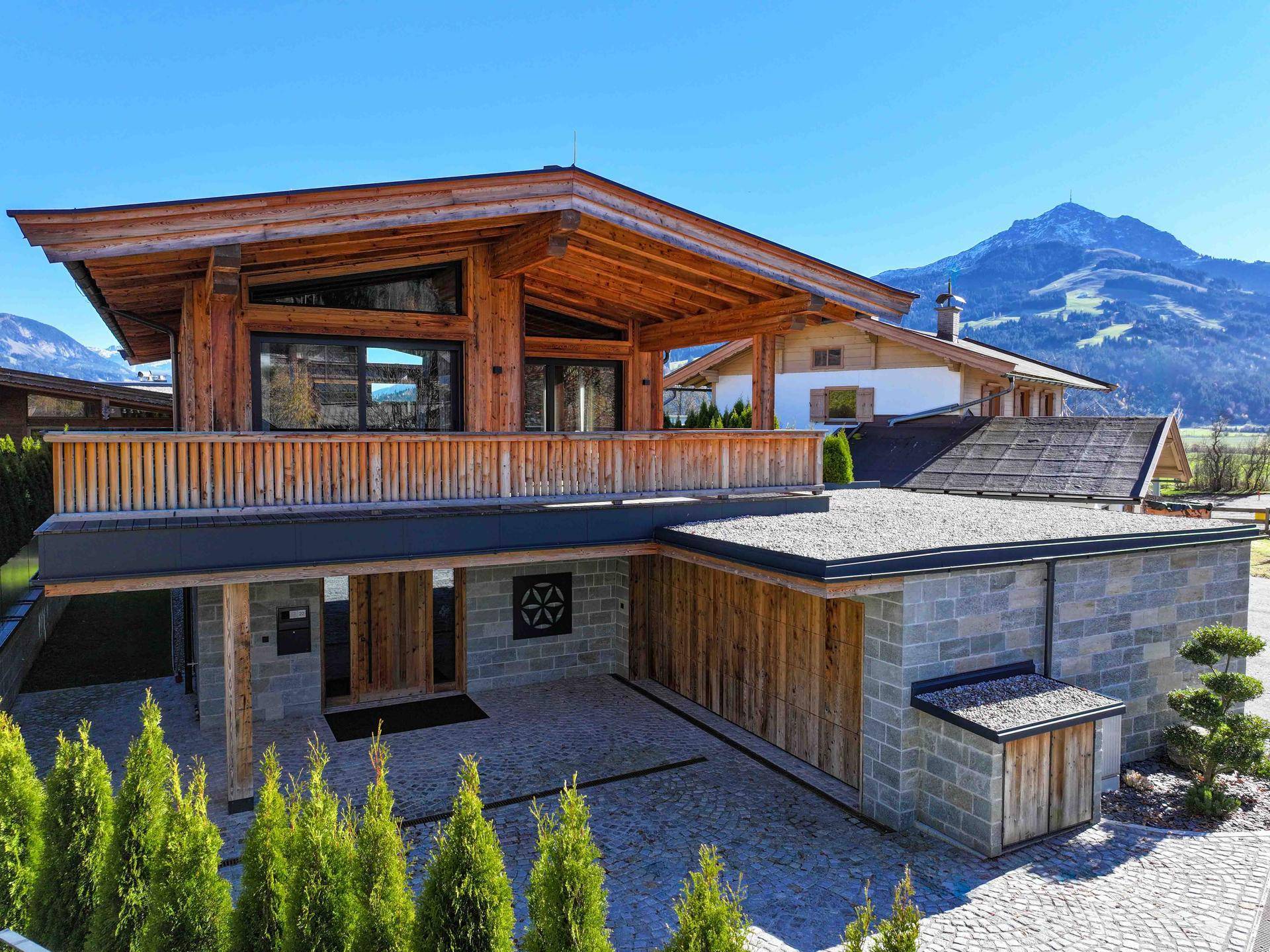 Attraktives Chalet mit Holzfassade, Balkon und Bergblick in sonniger Lage.