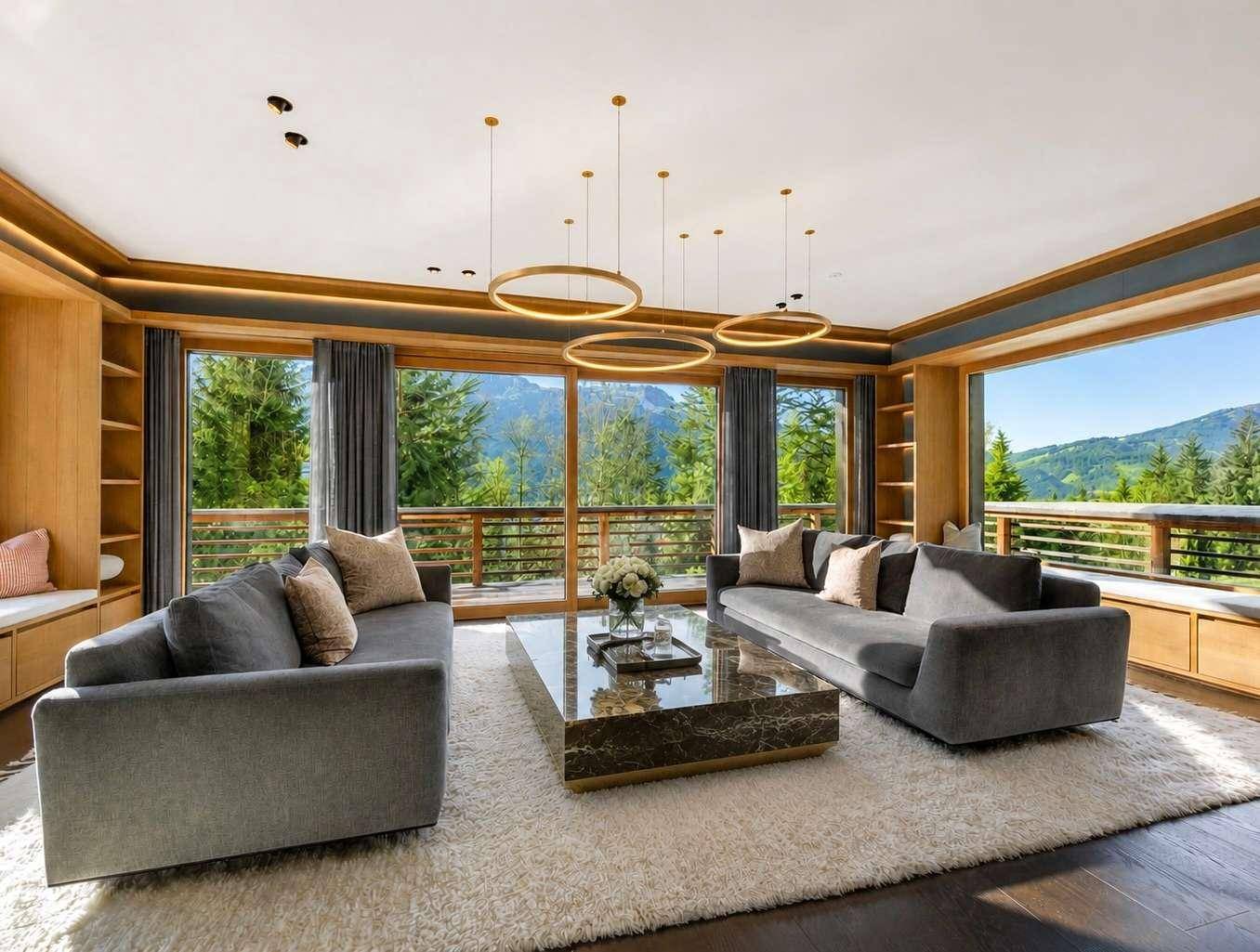 Elegantes Wohnzimmer mit raumhohen Fenstern, Holzakzenten und atemberaubendem Bergblick.