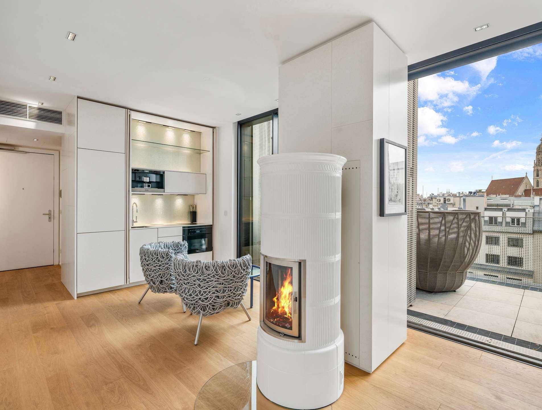 Kompakte, integrierte Küche mit Kachelofen und Zugang zu einer Terrasse mit Stadtblick.