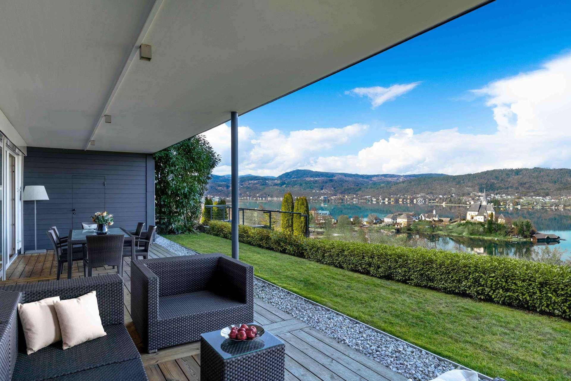Geräumige Terrasse mit Ess- und Lounge-Bereich, bietet einen weiten Blick auf den See.
