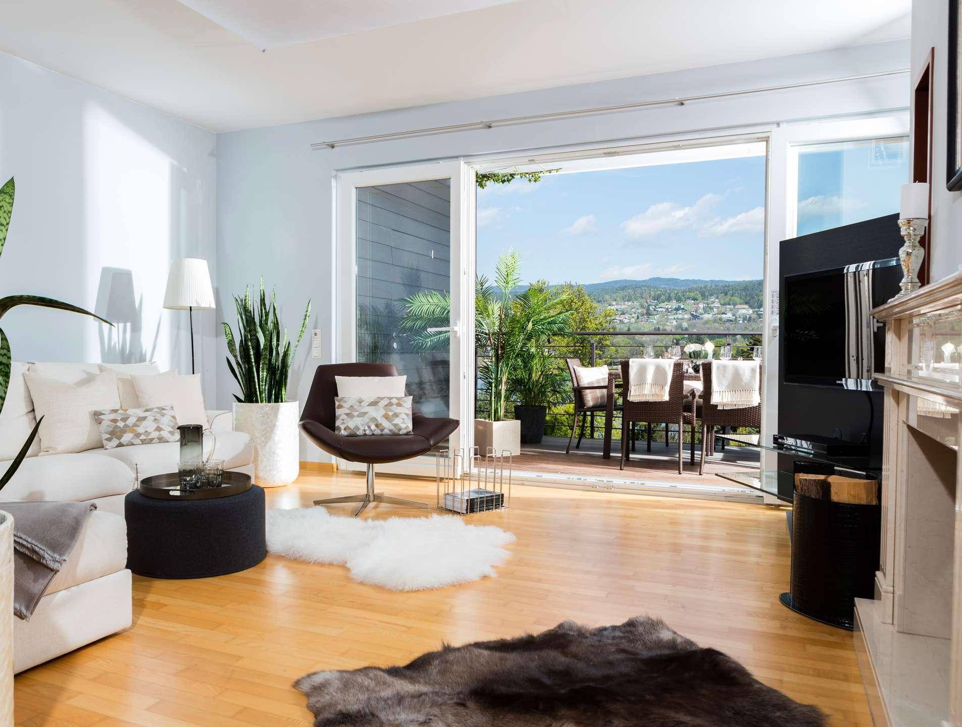 Geräumiges Wohnzimmer mit Kamin, bequemen Sitzgelegenheiten und Zugang zu einem Balkon mit Weitblick.