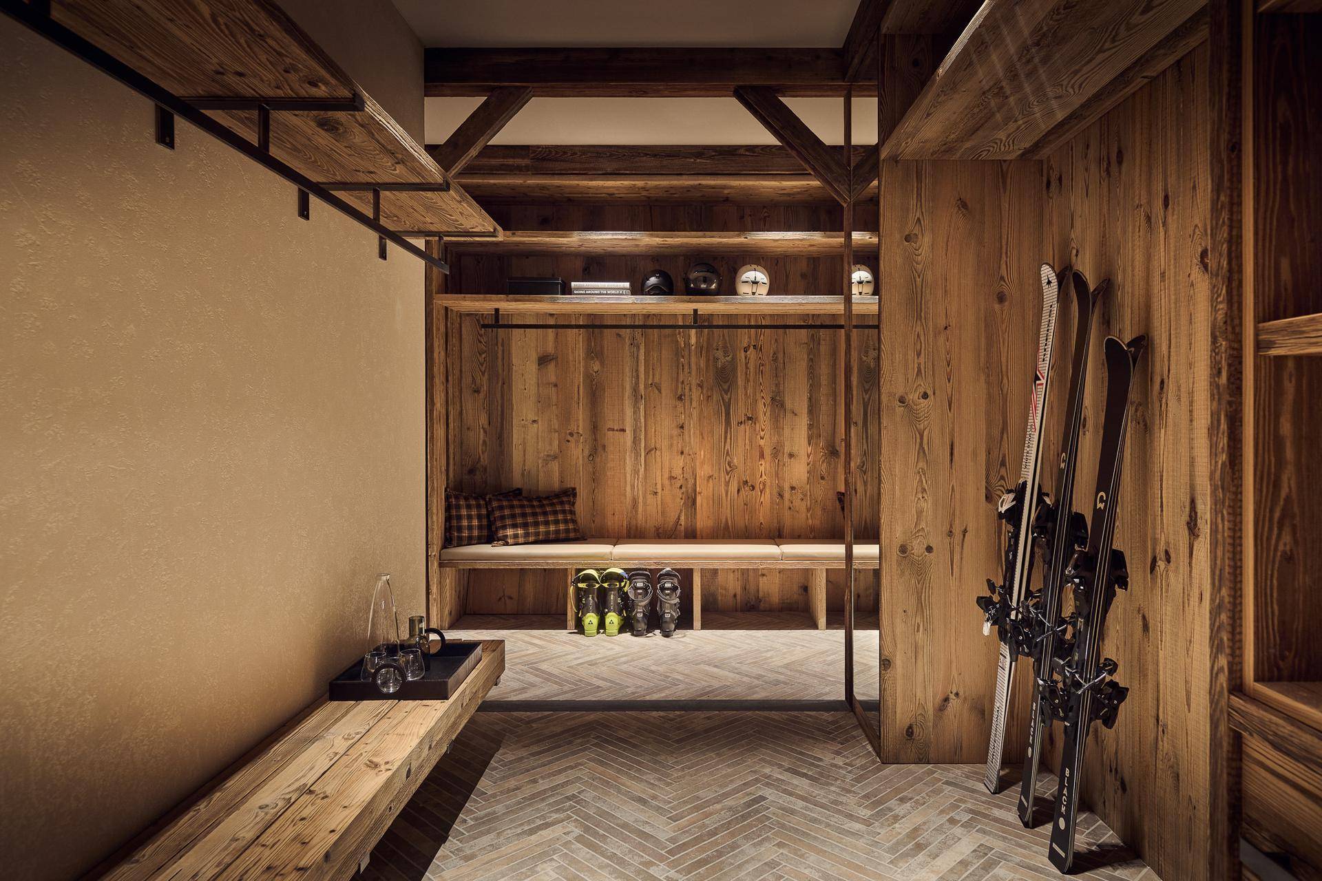 Praktischer Skiraum mit Holzbänken, Stauraum und Trockenmöglichkeiten für Ausrüstung.