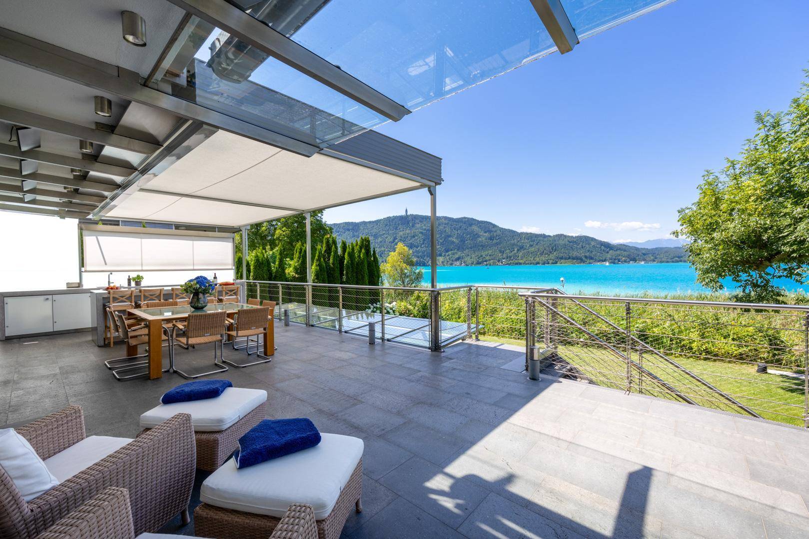 Großzügige Terrasse mit Lounge- und Essbereich, überdacht und mit weitem Blick auf den See.