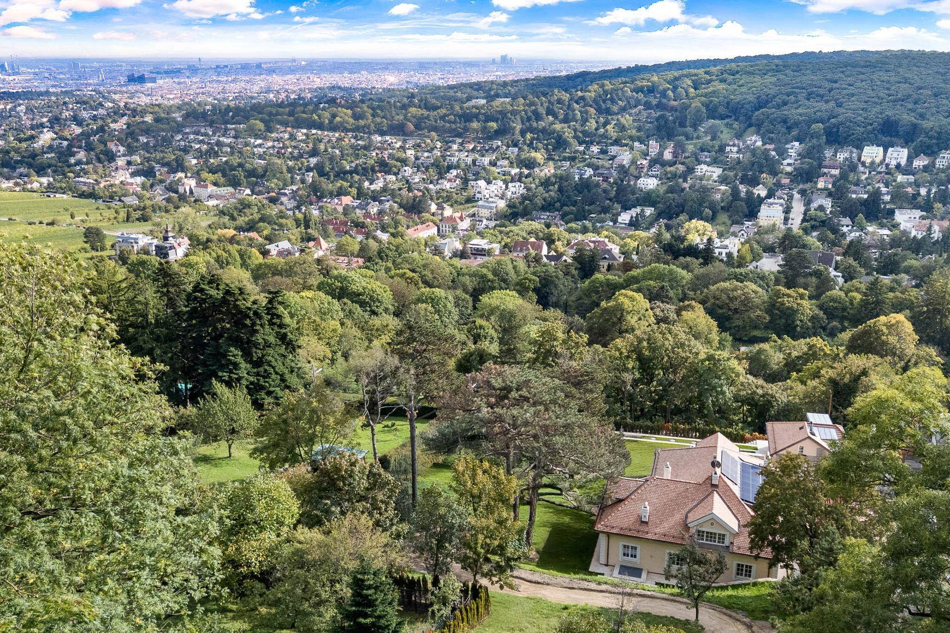 Weitläufige grüne Umgebung mit Blick auf die Stadt und umliegende Wälder.