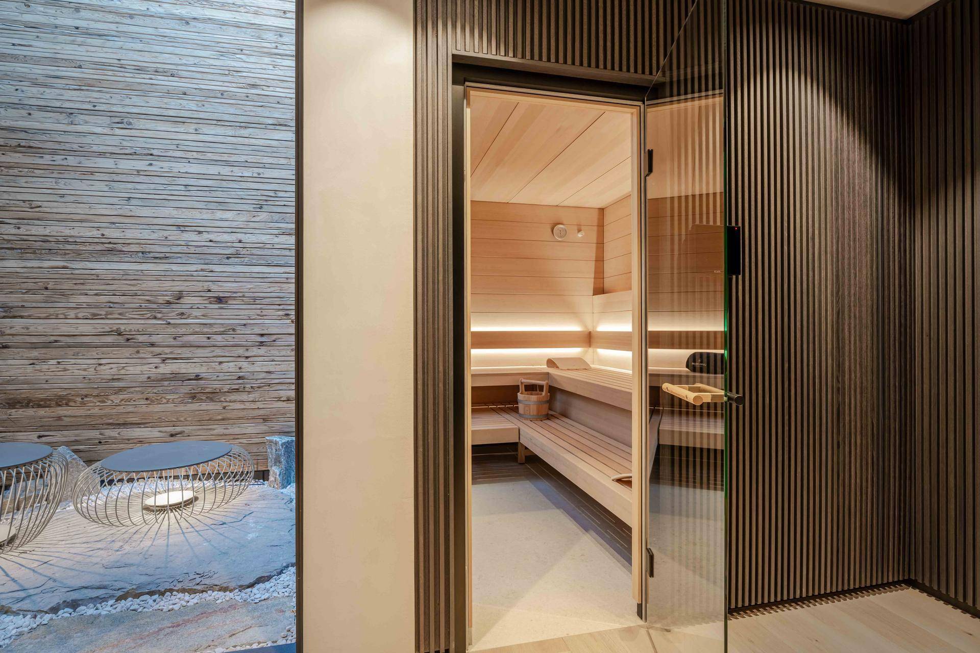Moderne Sauna mit Holzverkleidung und indirekter Beleuchtung für entspannende Momente.
