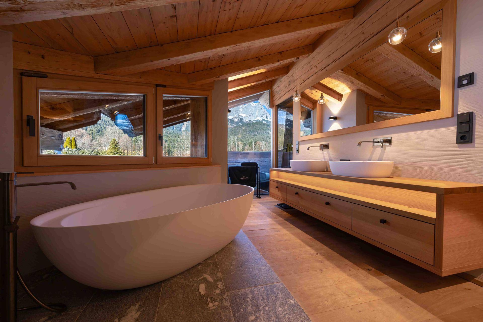 Elegantes Badezimmer mit freistehender Badewanne, Doppelwaschbecken und Bergblick.