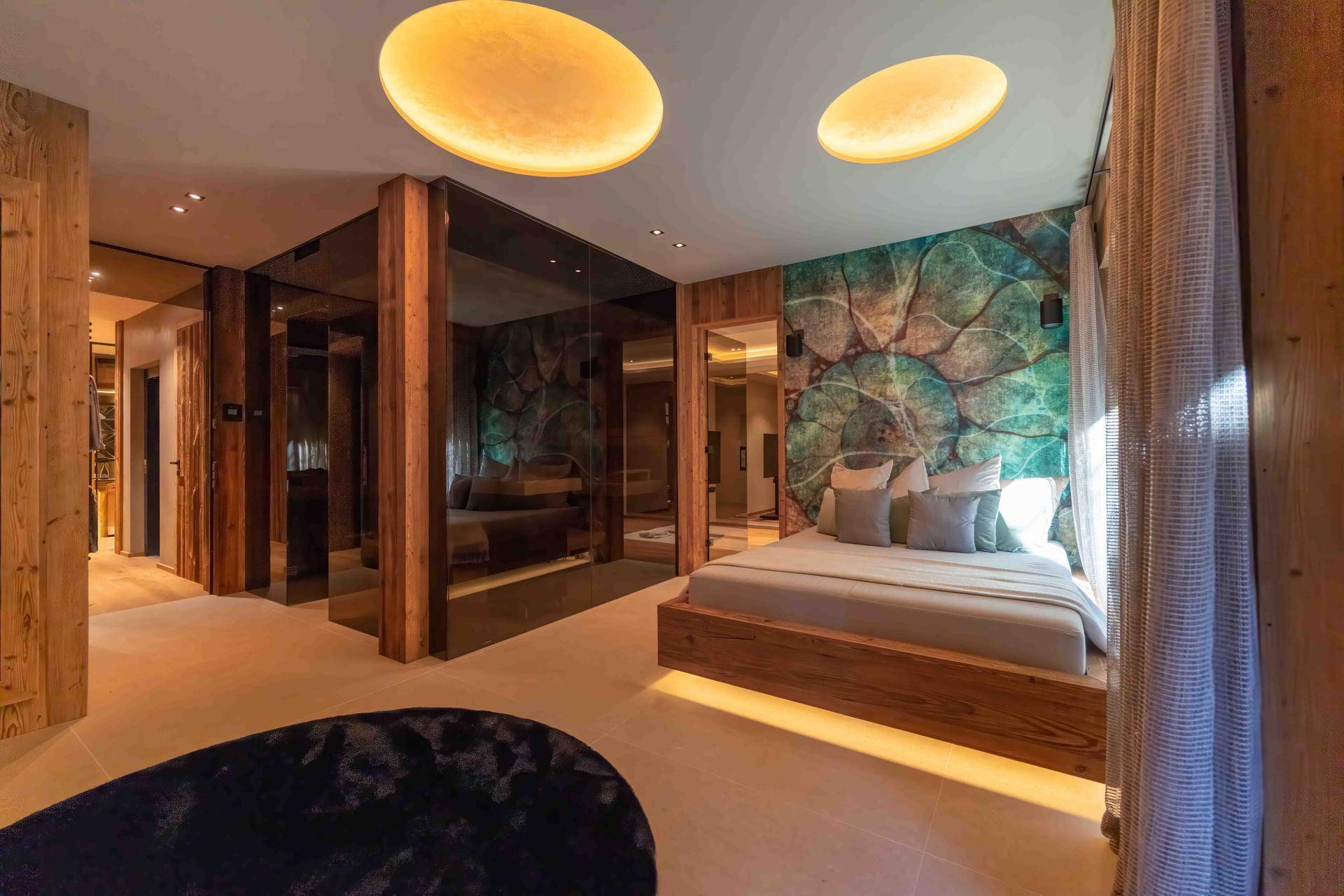 Modernes Schlafzimmer mit Holzbett, farbiger Wandgestaltung und indirekter Beleuchtung.