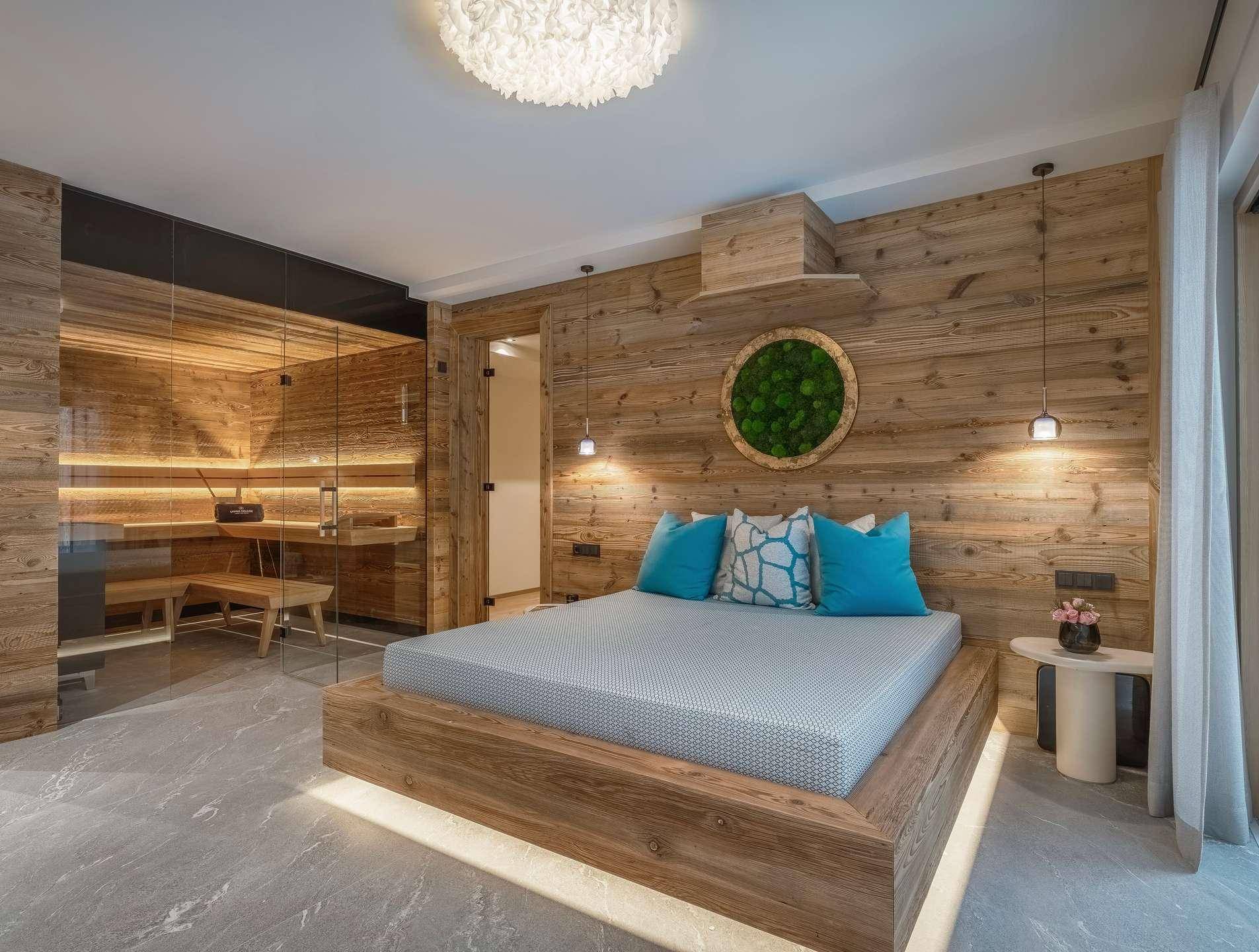 Exklusives Schlafzimmer mit Holzwand, integrierter Sauna und stilvoller Beleuchtung für Entspannung.